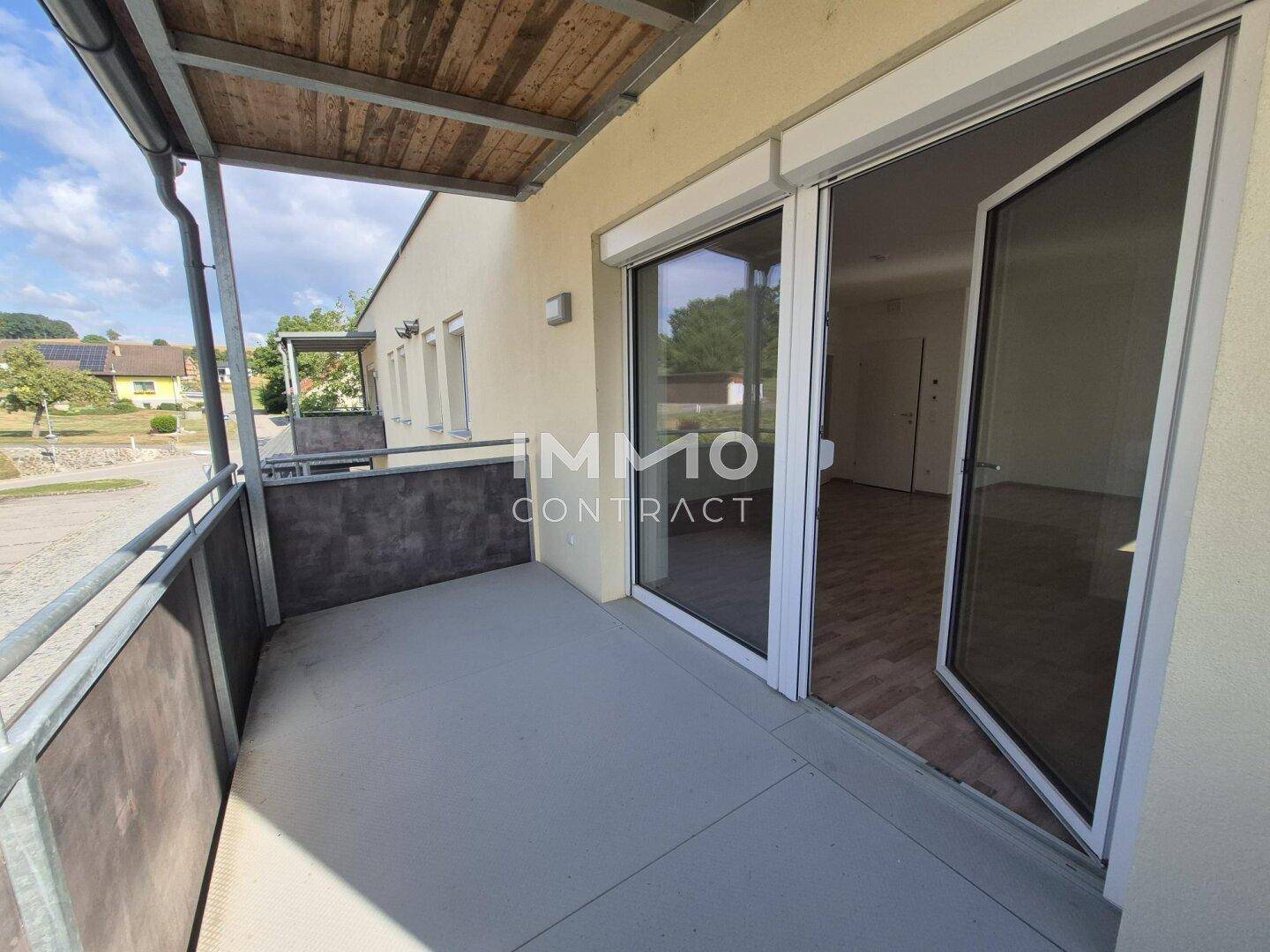 Heller Balkon mit Metallgeländer und Blick auf die grüne Umgebung.