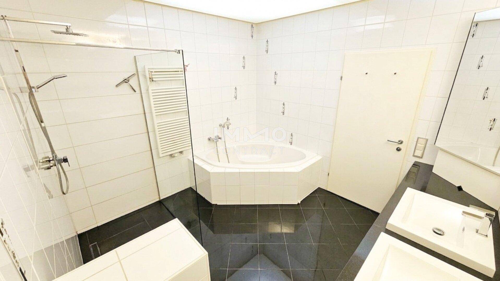 Geräumiges Badezimmer mit Eckbadewanne, Dusche und beheiztem Handtuchhalter.