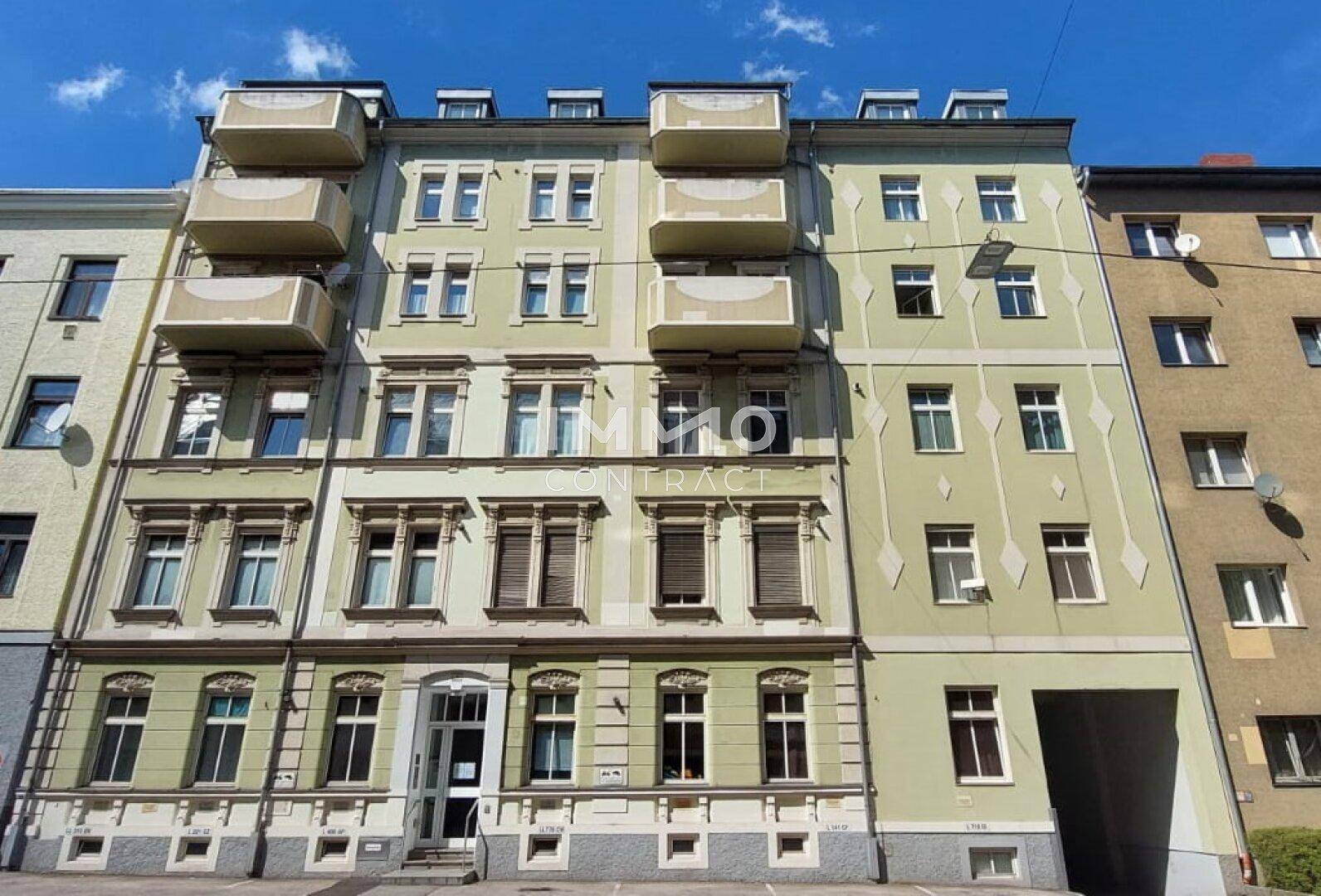 Historische Fassade eines Mehrfamilienhauses mit mehreren Balkonen und klassischen Details.