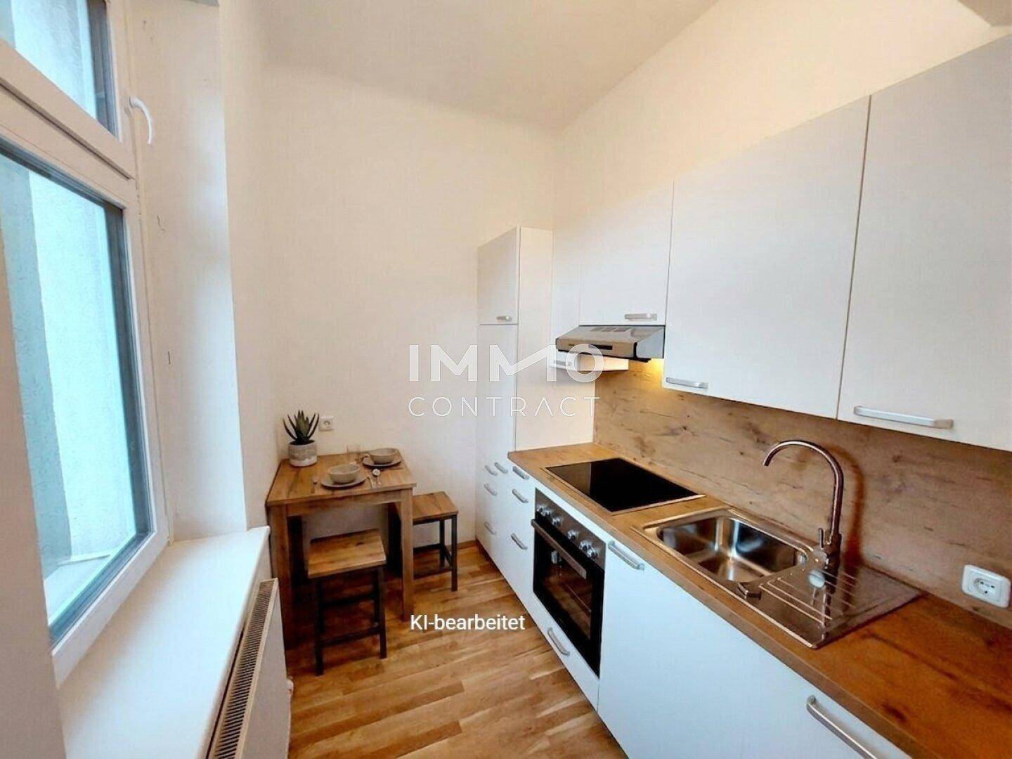 Moderne Küche mit weißen Schränken, Holzarbeitsplatte und kleinem Essbereich am Fenster.