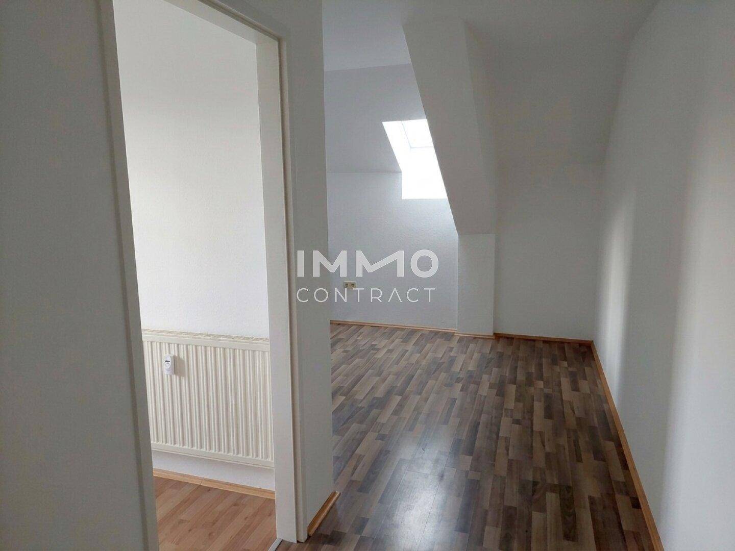 Heller Flur mit Laminatboden, der zu einem weiteren Raum mit Dachfenster führt.