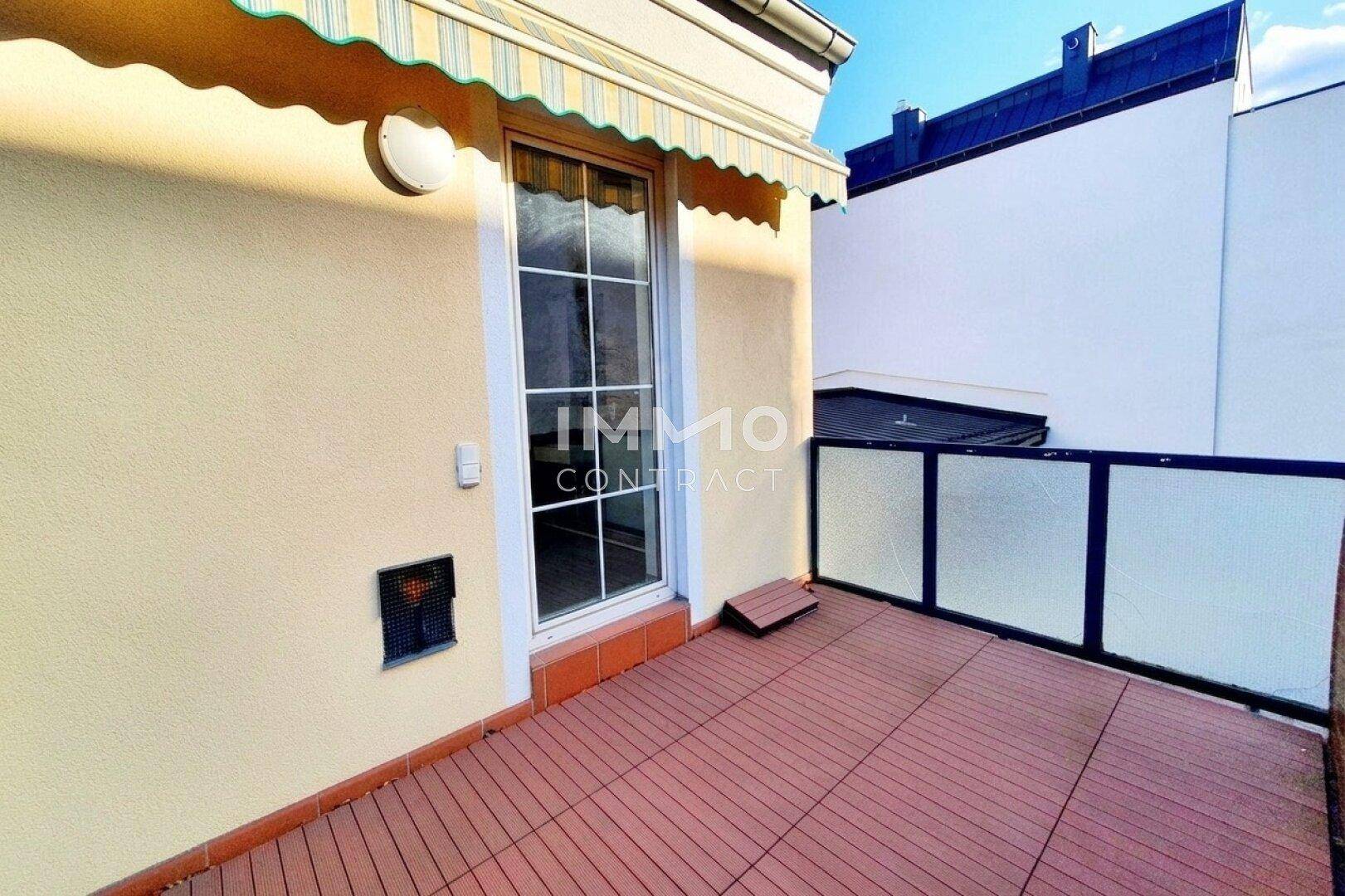 Heller Balkon mit Markise und Fliesenboden, ideal für entspannte Stunden im Freien.