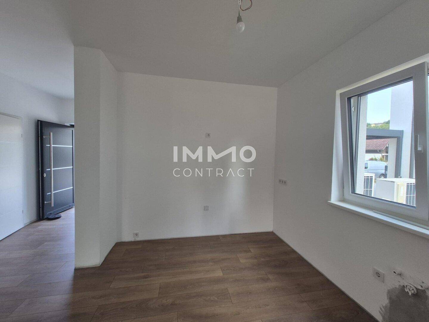 Unmöblierter Raum mit Laminatboden und einem Fenster, bereit für die individuelle Gestaltung.