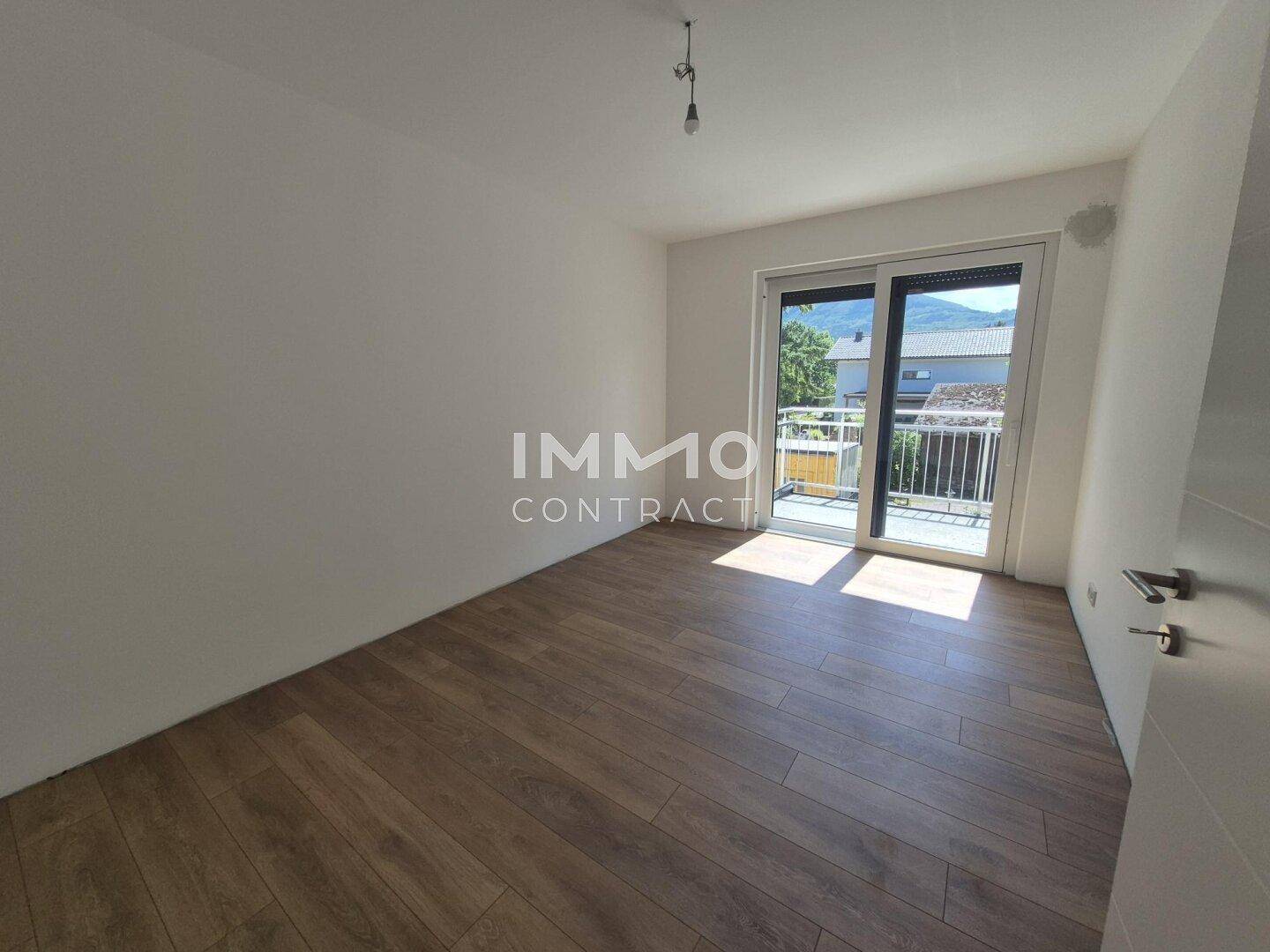 Schlafzimmer mit Laminatboden und Balkonzugang, bietet einen schönen Blick auf die Berge.
