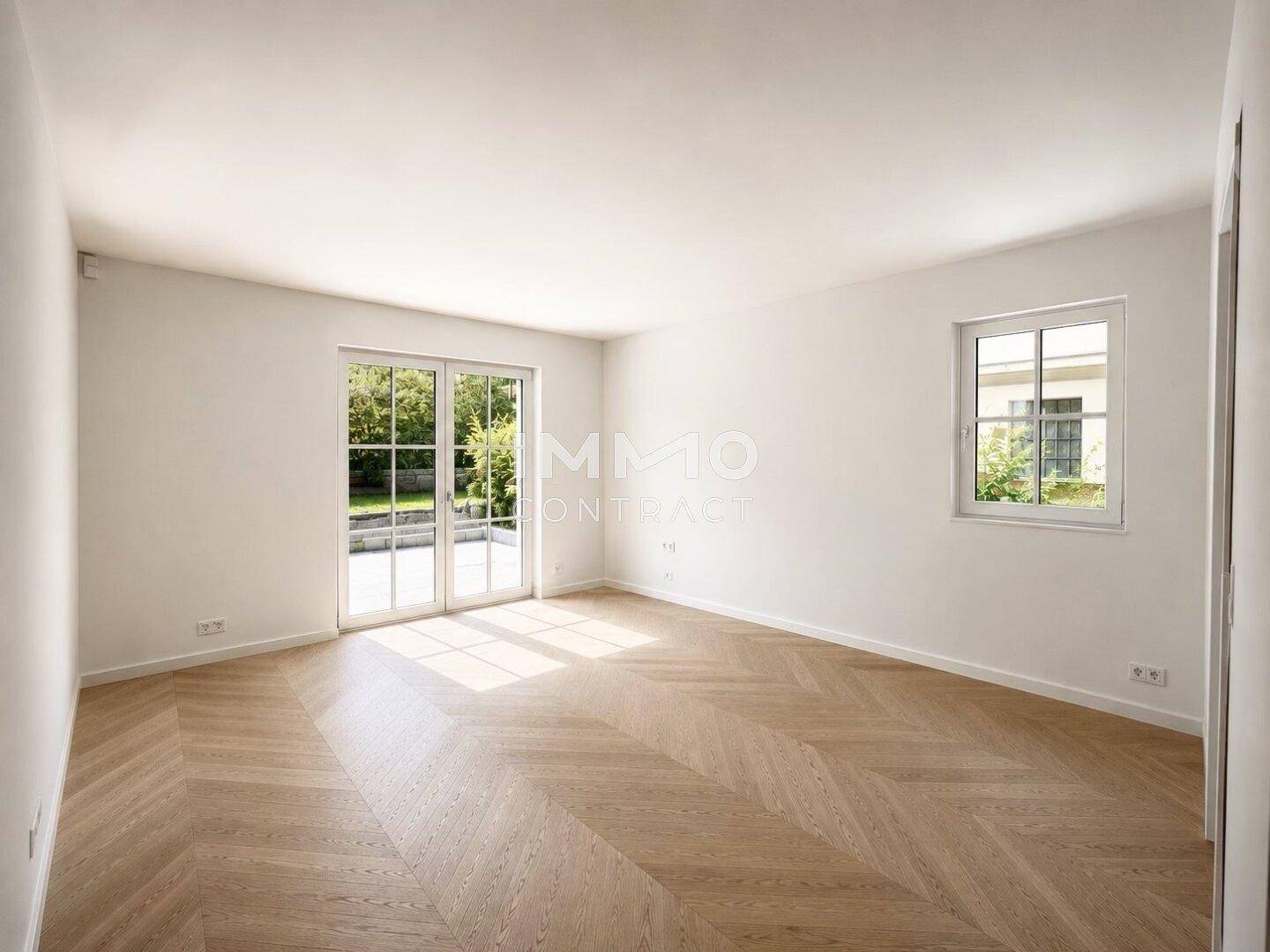 Heller Wohnraum mit Fischgrätparkett und Fenstertüren, die viel Tageslicht hereinlassen.