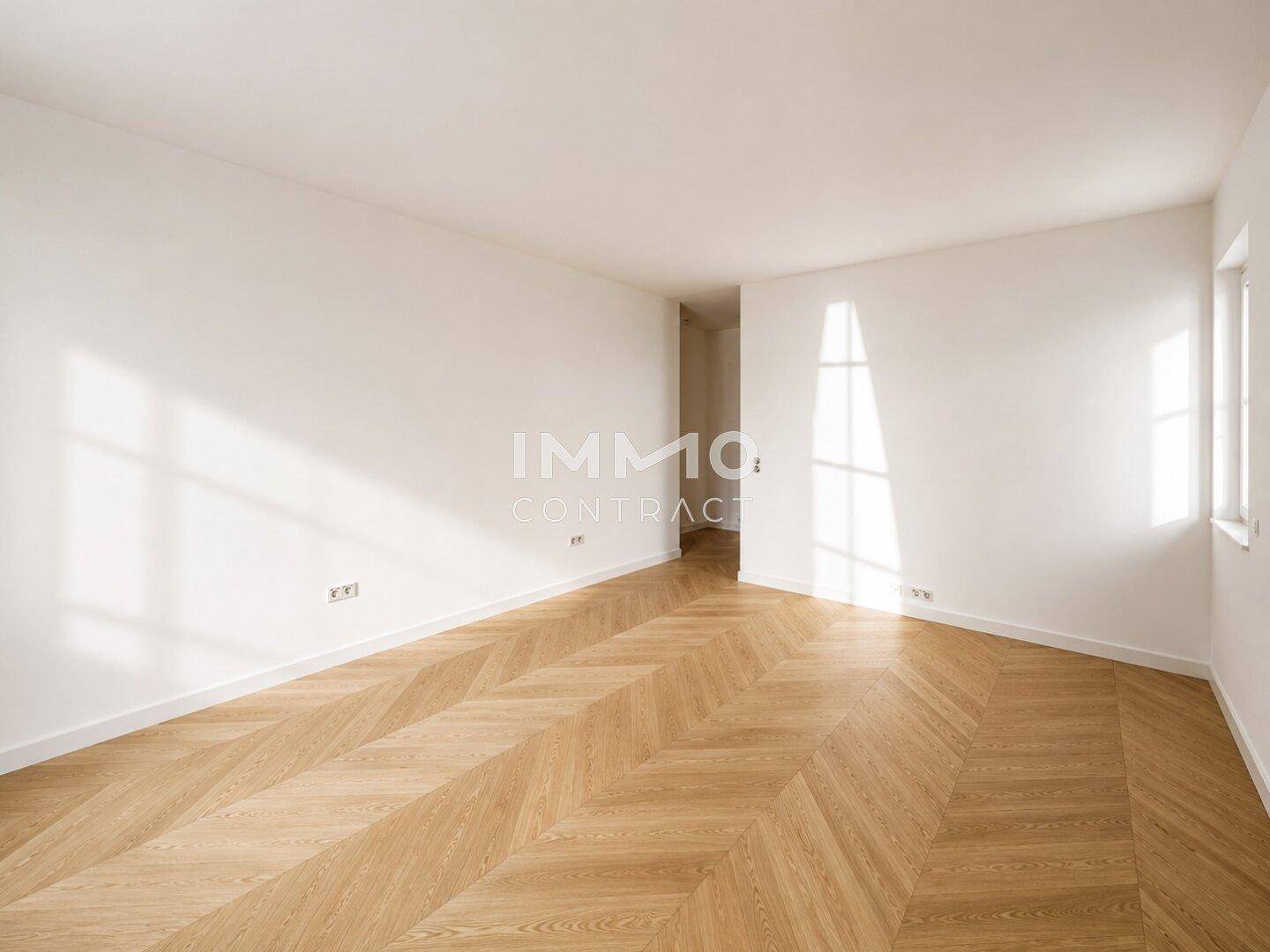 Geräumiger, heller Raum mit Fischgrätparkett und viel natürlichem Lichteinfall durch die Fenster.