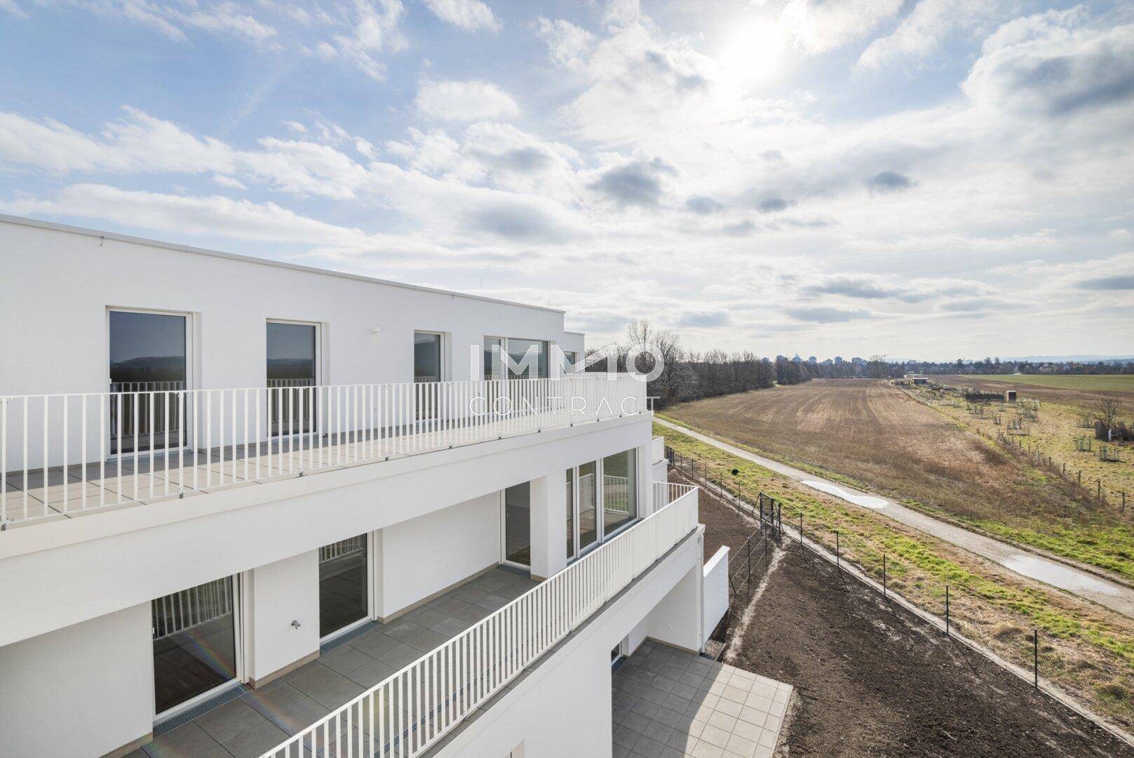 Moderne Wohnanlage mit Balkonen und weitem Blick über die umliegende Landschaft.