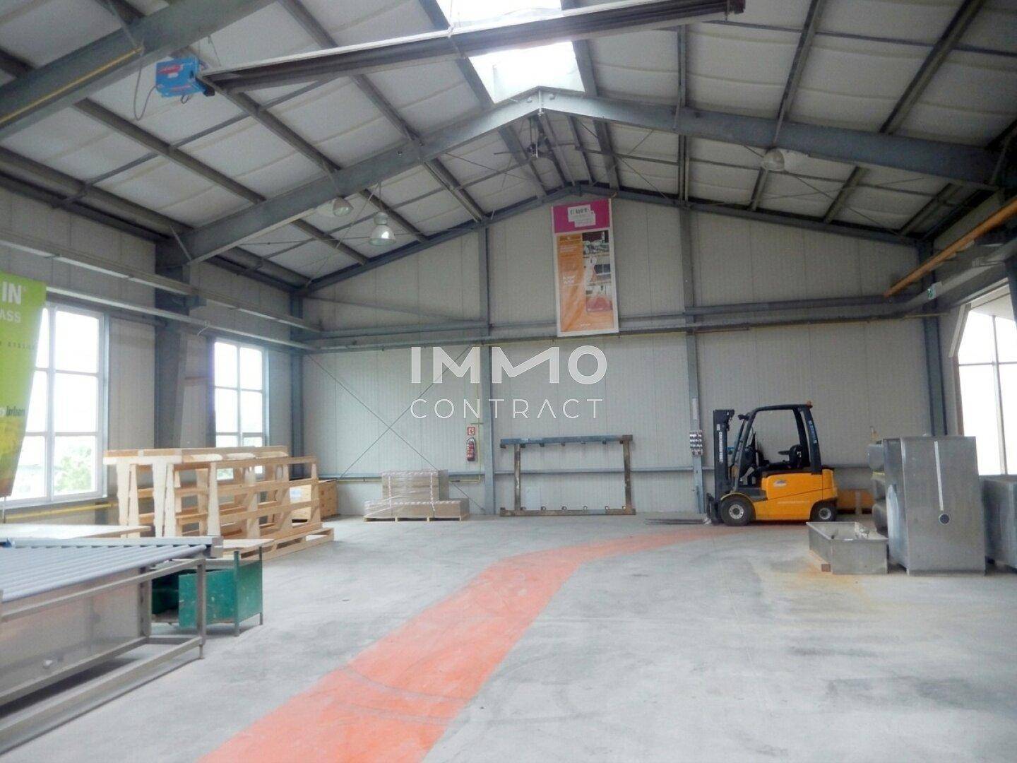 Geräumige Lagerhalle mit einem Gabelstapler und viel freiem Raum, ideal für Logistik und Produktion.
