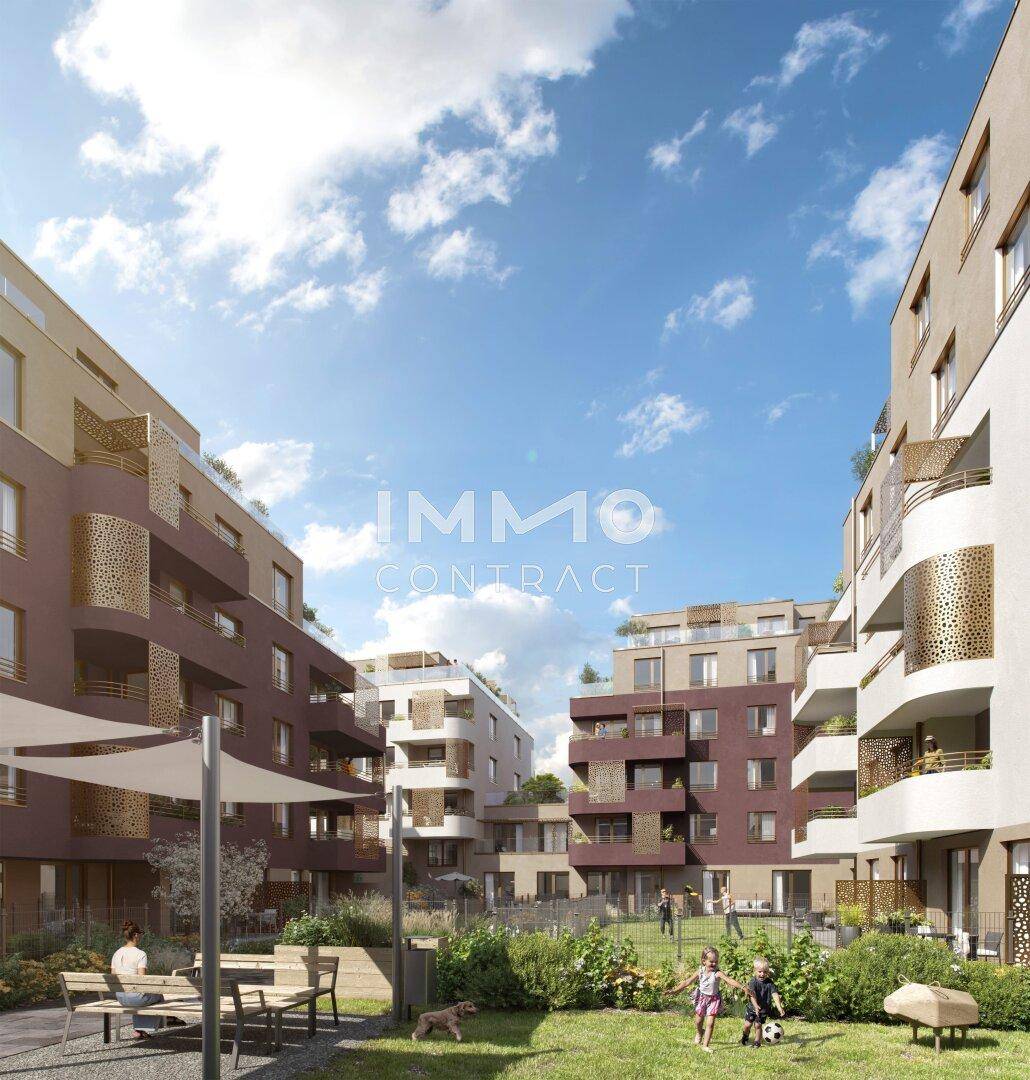 Begrünter Innenhof eines modernen Wohnkomplexes mit Sitzgelegenheiten und Spielbereich für Kinder.