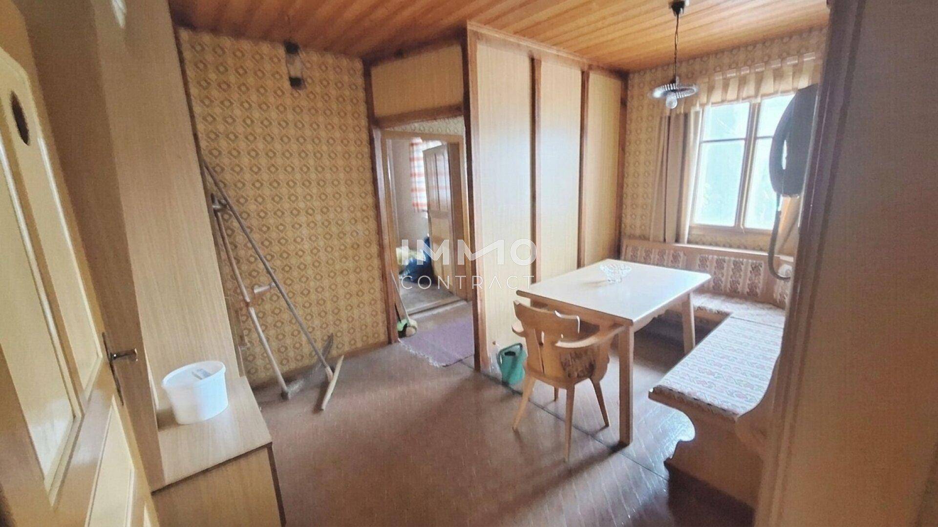 Gemütlicher Essbereich mit Holztäfelung, traditioneller Eckbank und einem Fenster in einem älteren Gebäude.