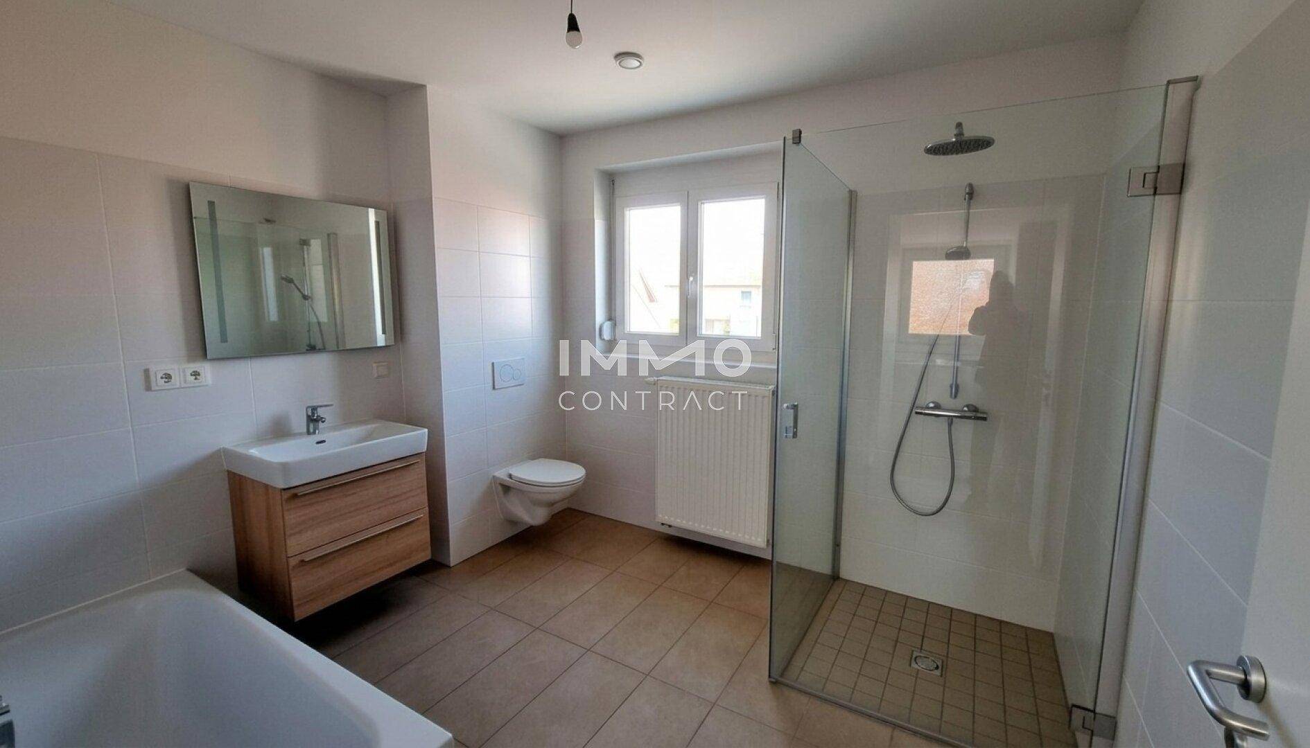 Modernes Badezimmer mit Badewanne, ebenerdiger Dusche, Einzelwaschbecken und Fenster.