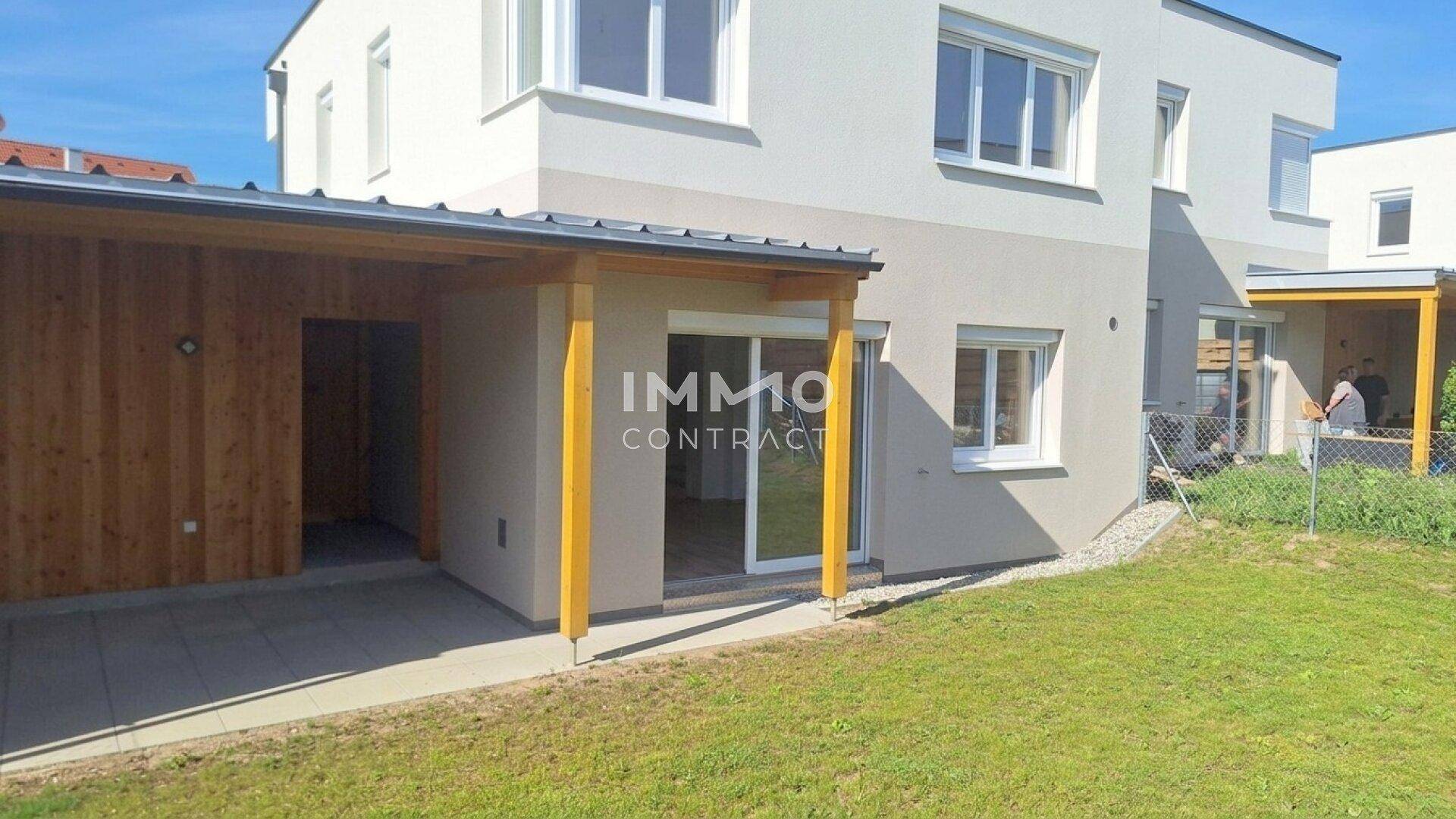 Hinteransicht des Hauses mit überdachter Terrasse und Gartenbereich, ideal für entspannte Stunden im Freien.