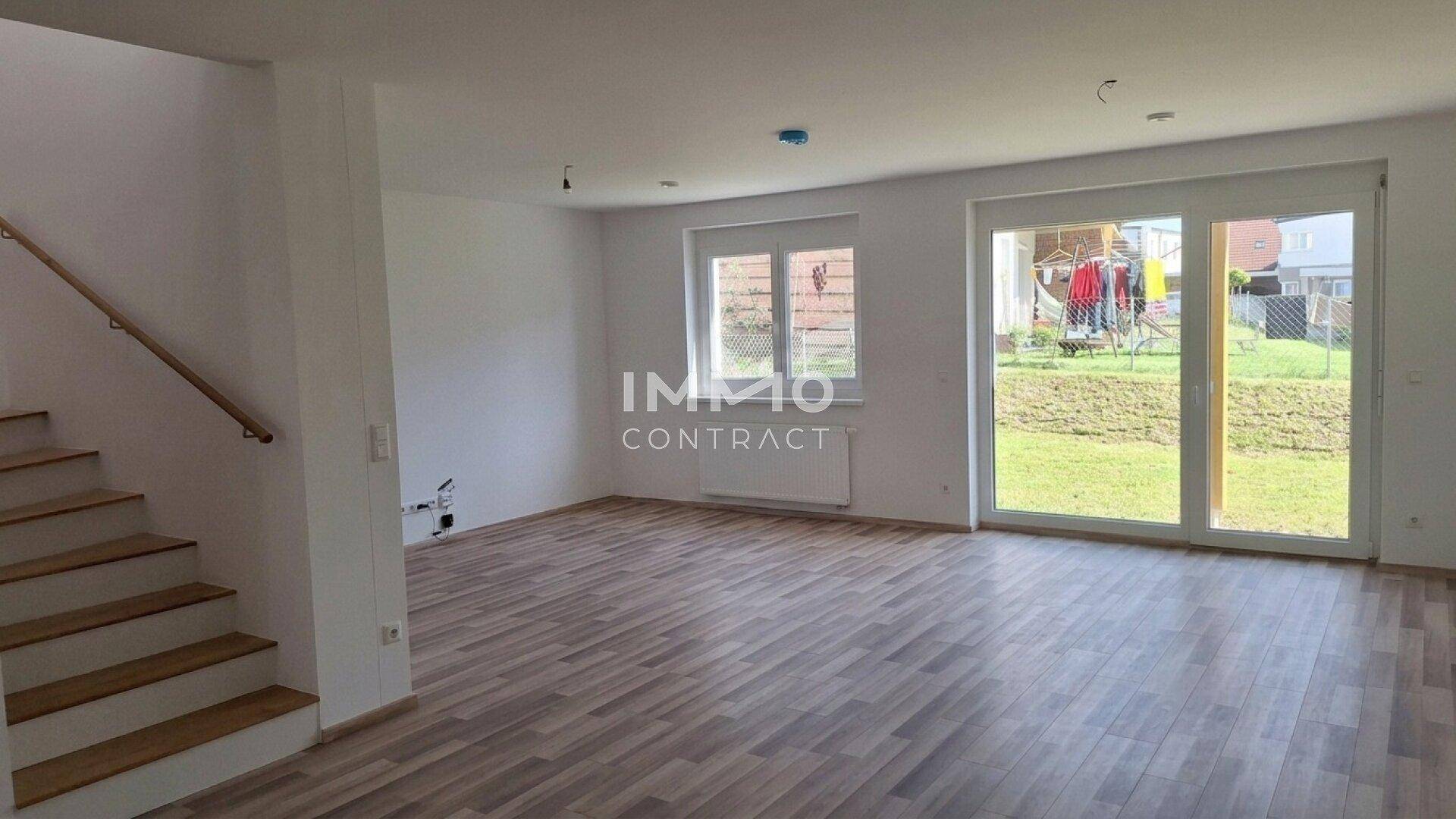 Geräumiger Wohnraum mit großen Fenstern und Blick ins Grüne, ideal für individuelle Gestaltungsmöglichkeiten.