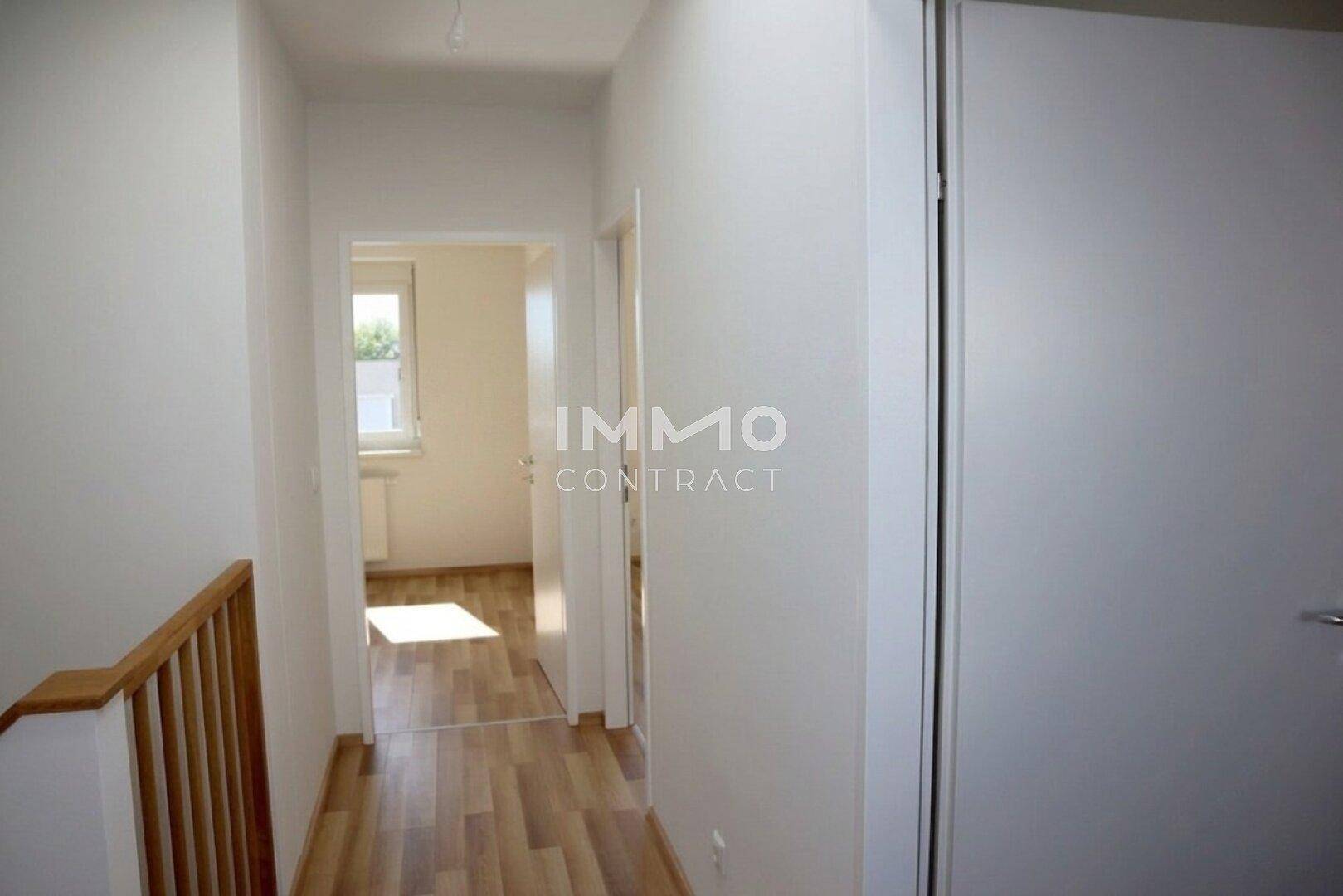 Obergeschoss-Flur mit Laminatboden und natürlichem Lichteinfall durch ein Fenster.