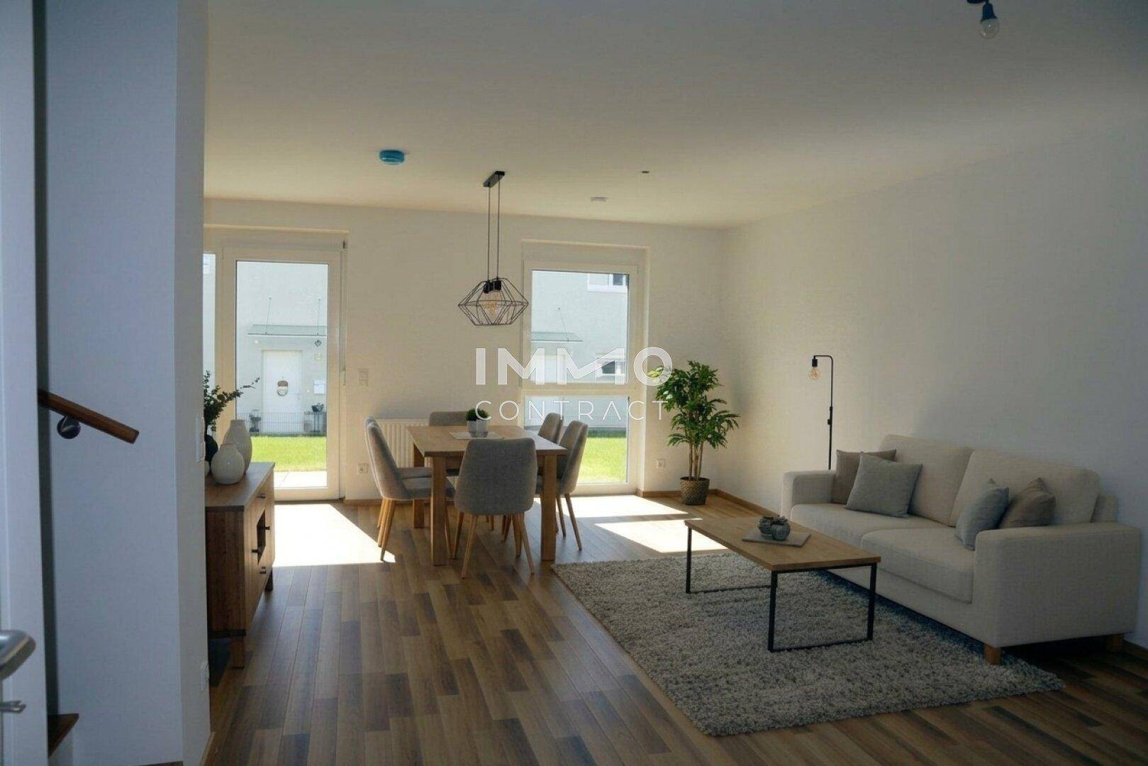 Heller offener Wohn- und Essbereich mit Holzboden und direktem Zugang zum Garten.
