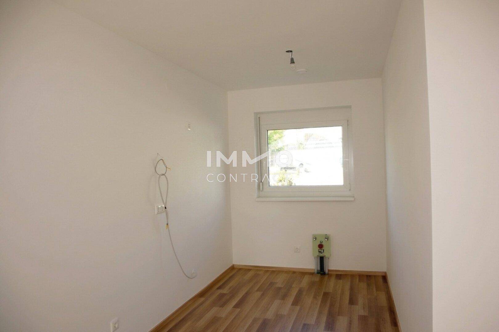 Kleines, helles Zimmer mit Laminatboden und Fenster, ideal als Schlaf- oder Arbeitszimmer.