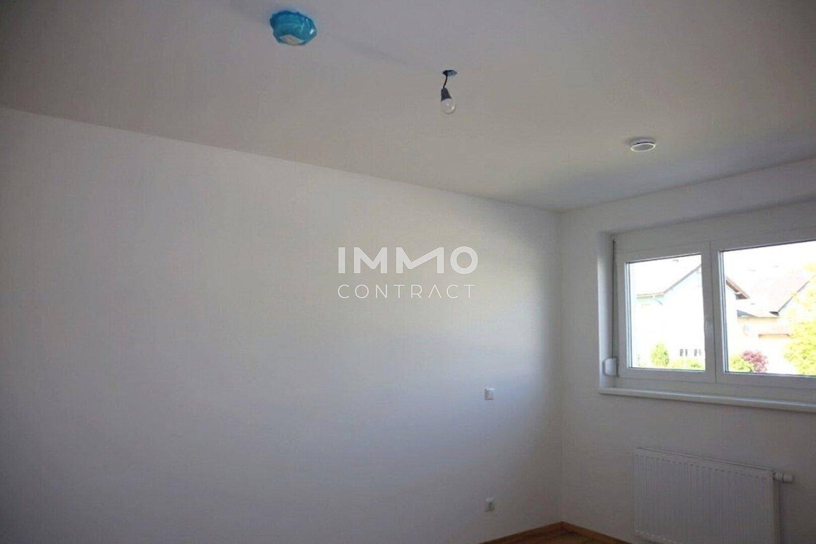 Leeres Zimmer mit Laminatboden und Fenster, bereit zur individuellen Gestaltung.