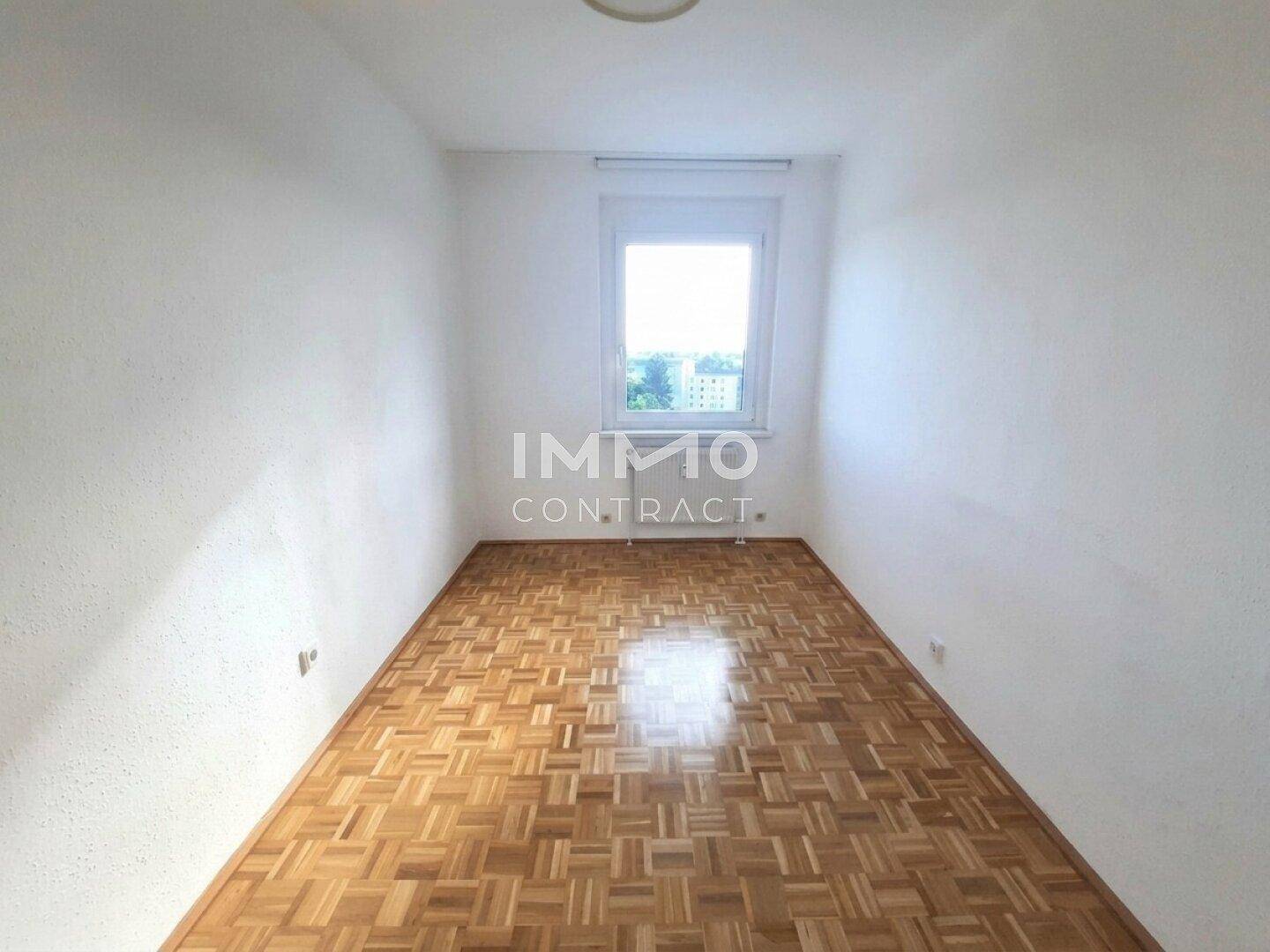 Ruhiges Schlafzimmer mit Parkettboden und einem Fenster, das eine angenehme Atmosphäre schafft.