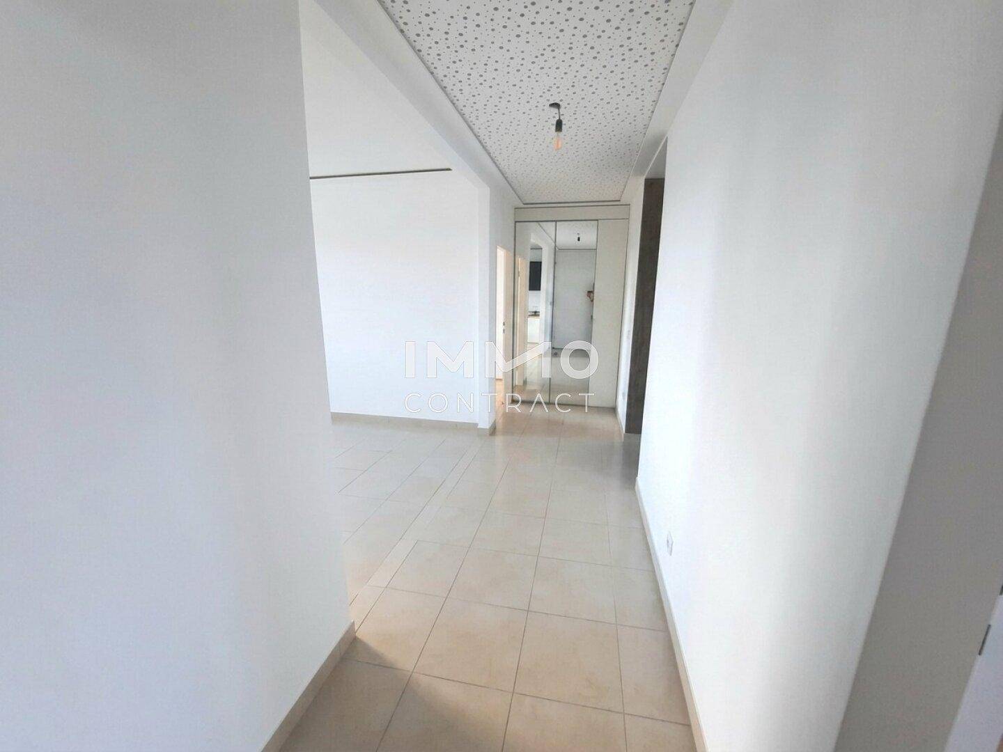 Heller Flur mit Fliesenboden und einem Spiegelschrank, der den Raum optisch vergrößert.