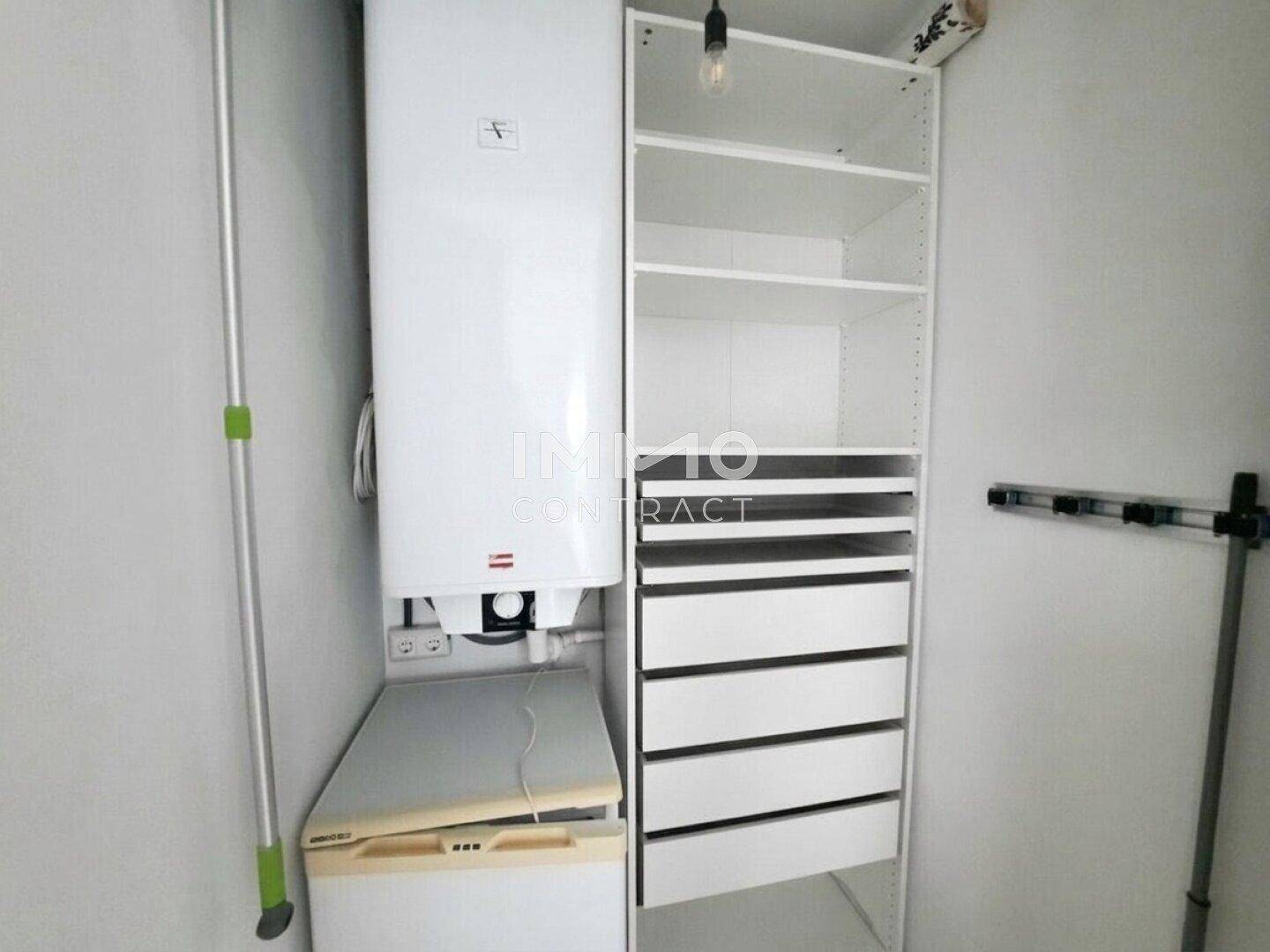Praktischer Abstellraum mit Warmwasserboiler und offenen Regalen für zusätzlichen Stauraum.