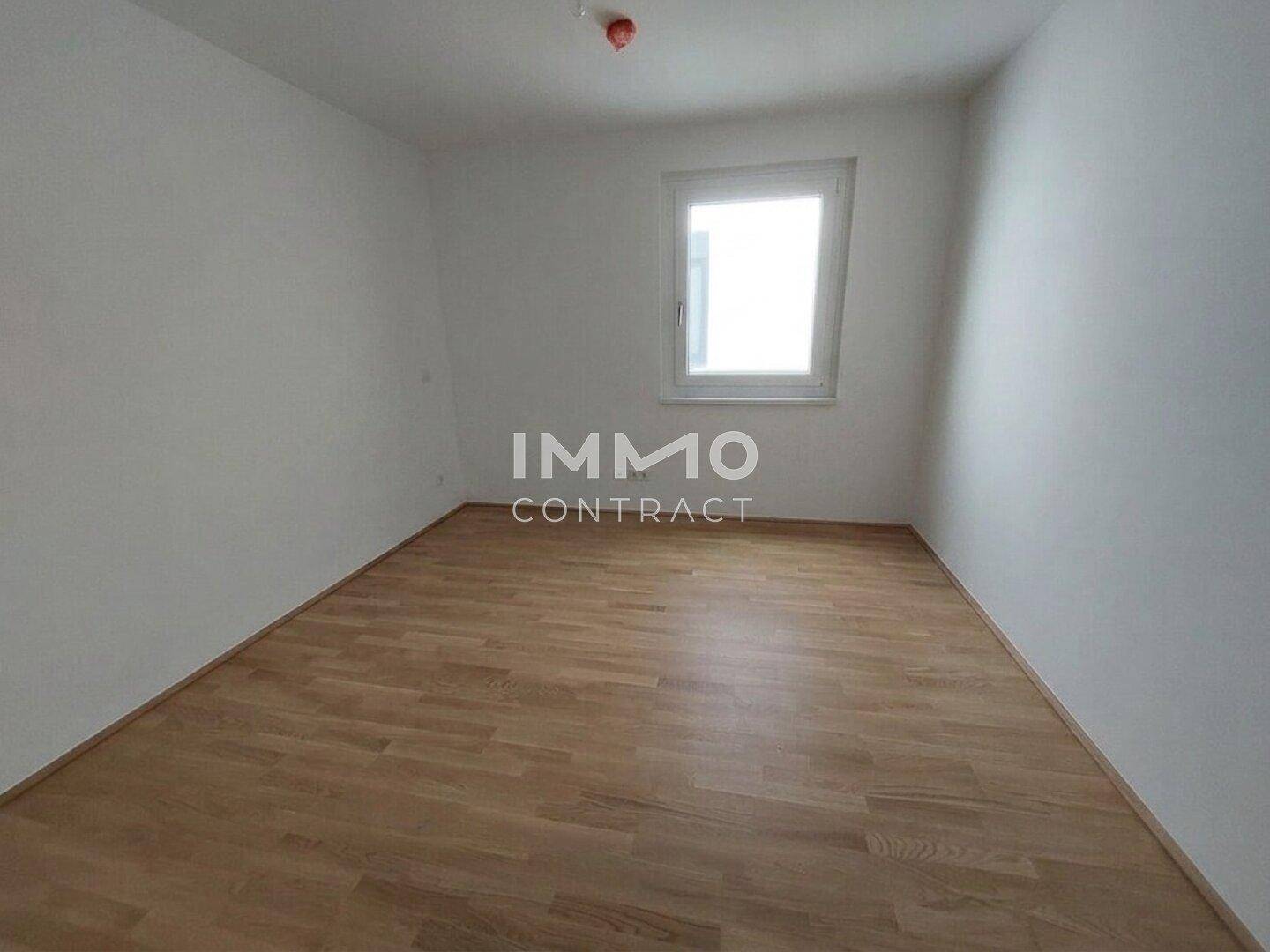 Helles, leeres Zimmer mit Holzparkettboden und einem Fenster, bereit zur individuellen Gestaltung.