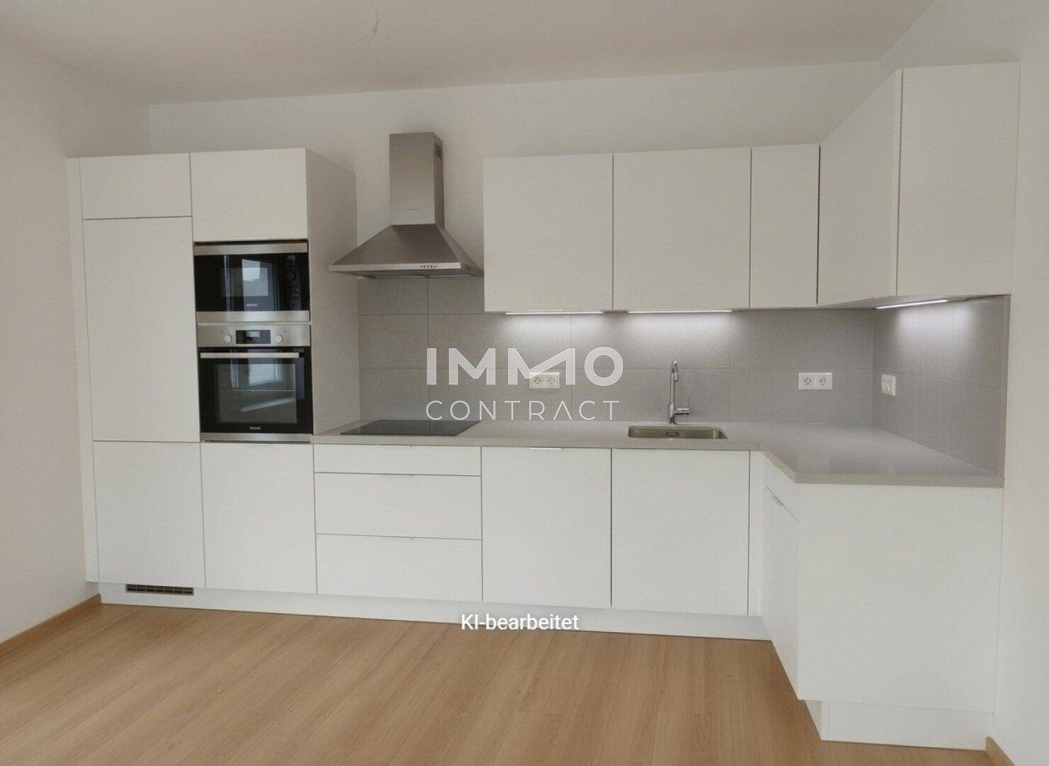 Moderne weiße Einbauküche mit integrierten Geräten und Dunstabzugshaube.