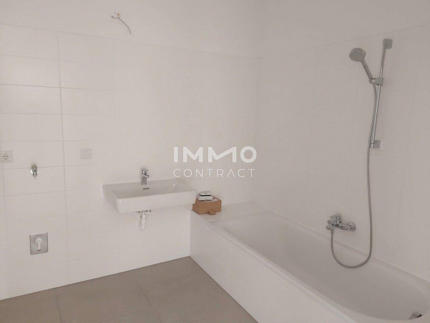 Modernes Badezimmer mit Badewanne, Waschbecken und weißen Fliesen.