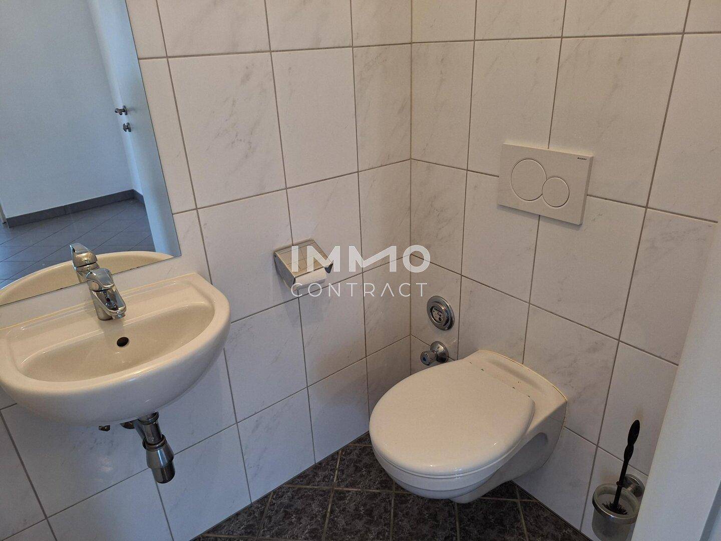 Kleines Gäste-WC mit wandhängender Toilette und Handwaschbecken.