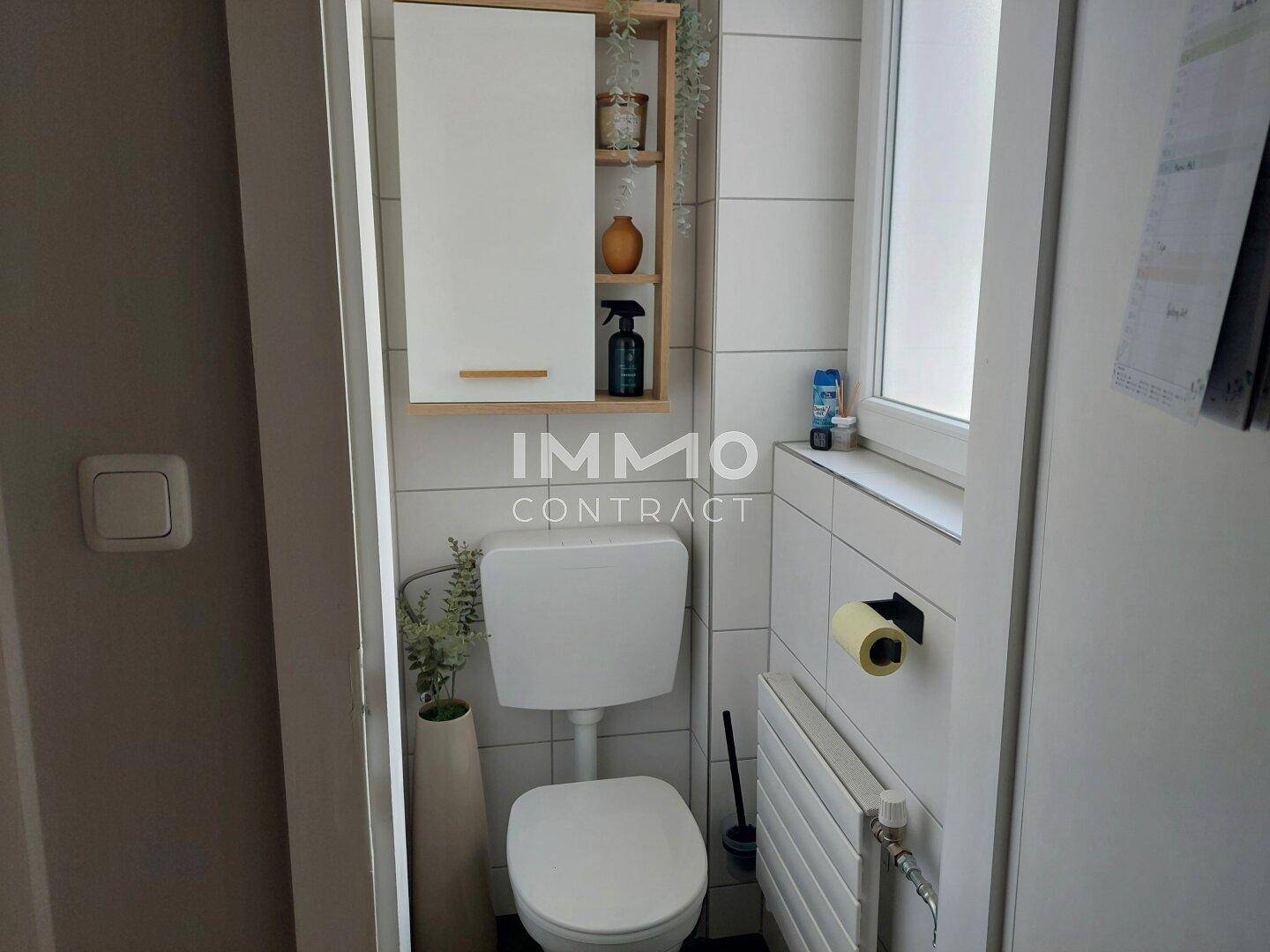 Kleines Gäste-WC mit Fenster, Toilette und Spiegelschrank.