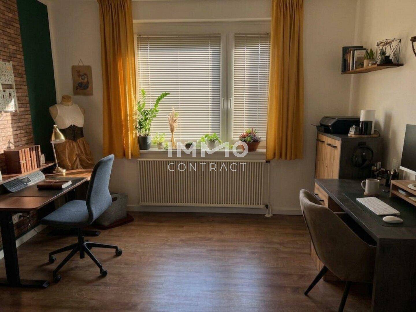 Helles Arbeitszimmer mit zwei Schreibtischen, gelben Vorhängen und Laminatboden.