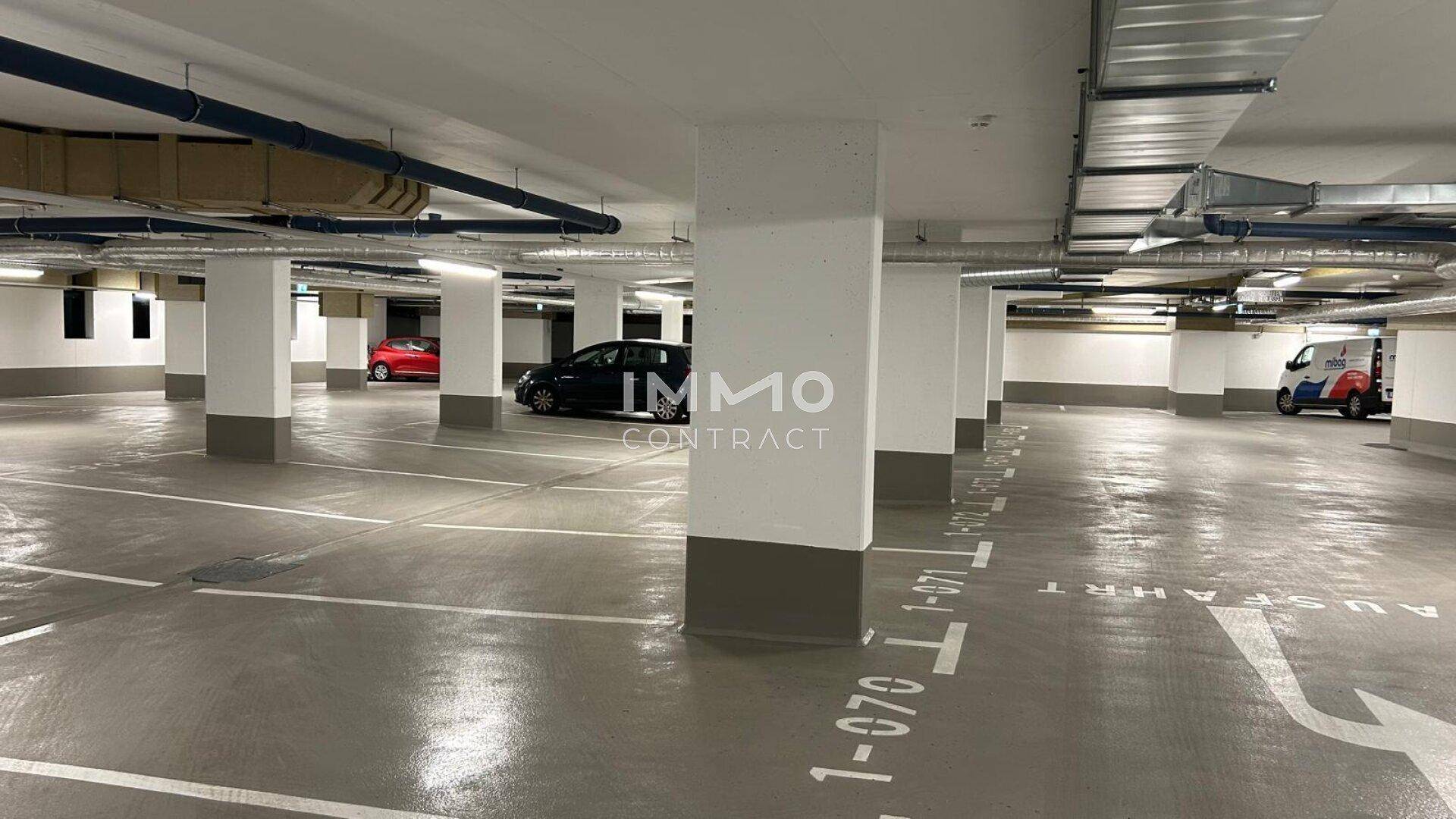 Geräumige Tiefgarage mit vielen Stellplätzen, Betonpfeilern und klar markierten Fahrspuren.