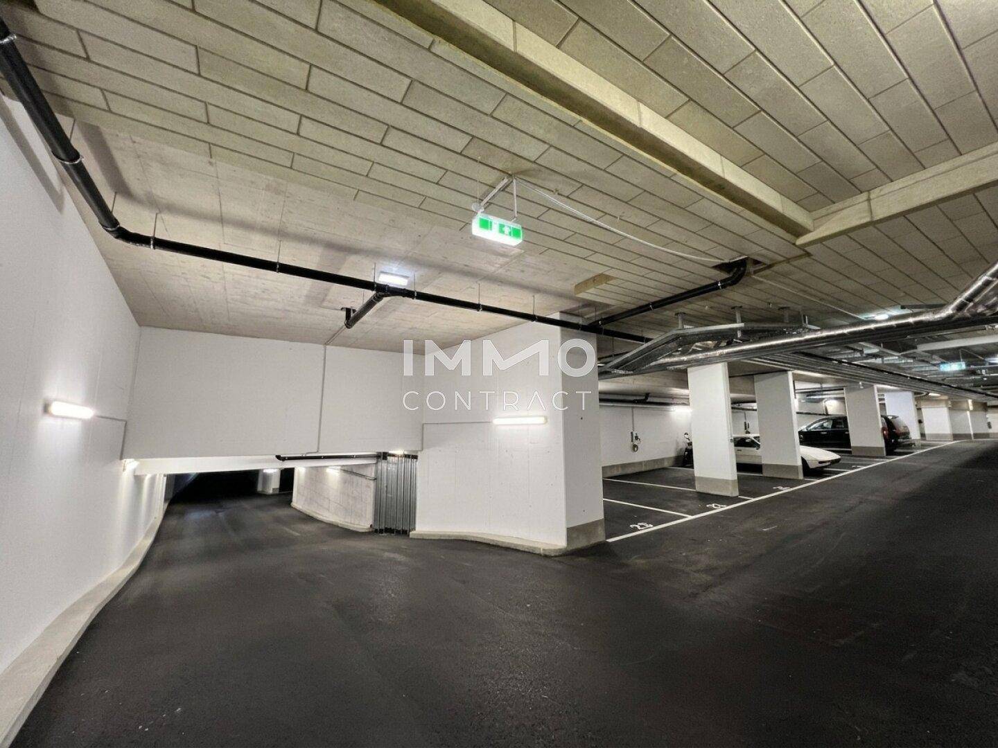 Geräumige Tiefgarage mit zahlreichen Parkplätzen, massiver Betonkonstruktion und funktionaler Beleuchtung.