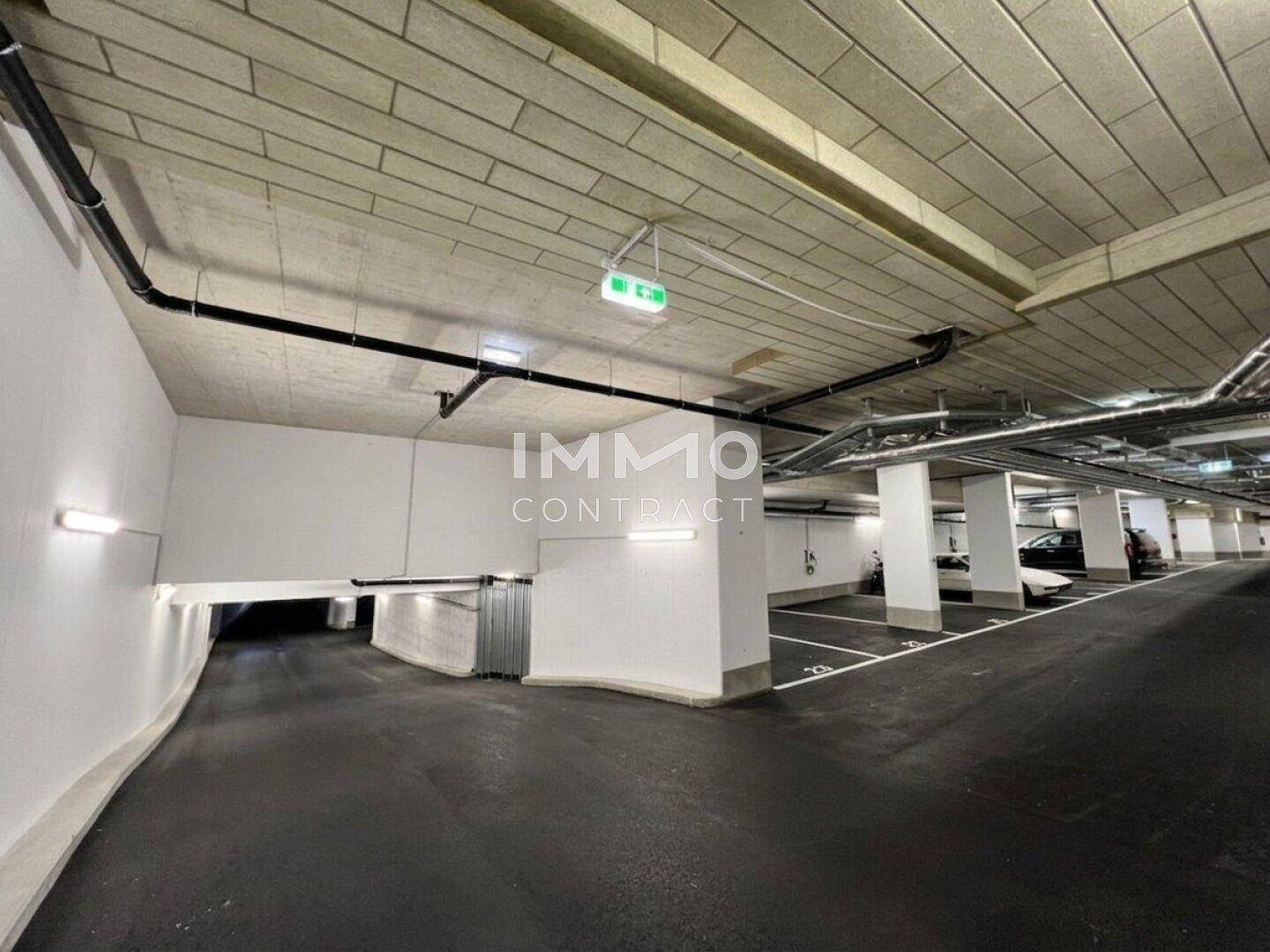 Einfahrt zu einer modernen Tiefgarage mit ausreichend Stellplätzen und guter Beleuchtung.