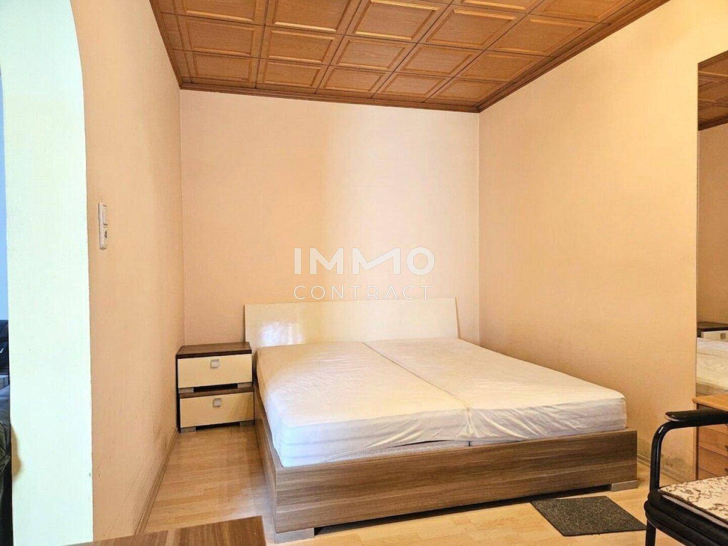Schlafzimmer mit Doppelbett, Nachttischen und Holzdecke, bietet einen ruhigen Rückzugsort.