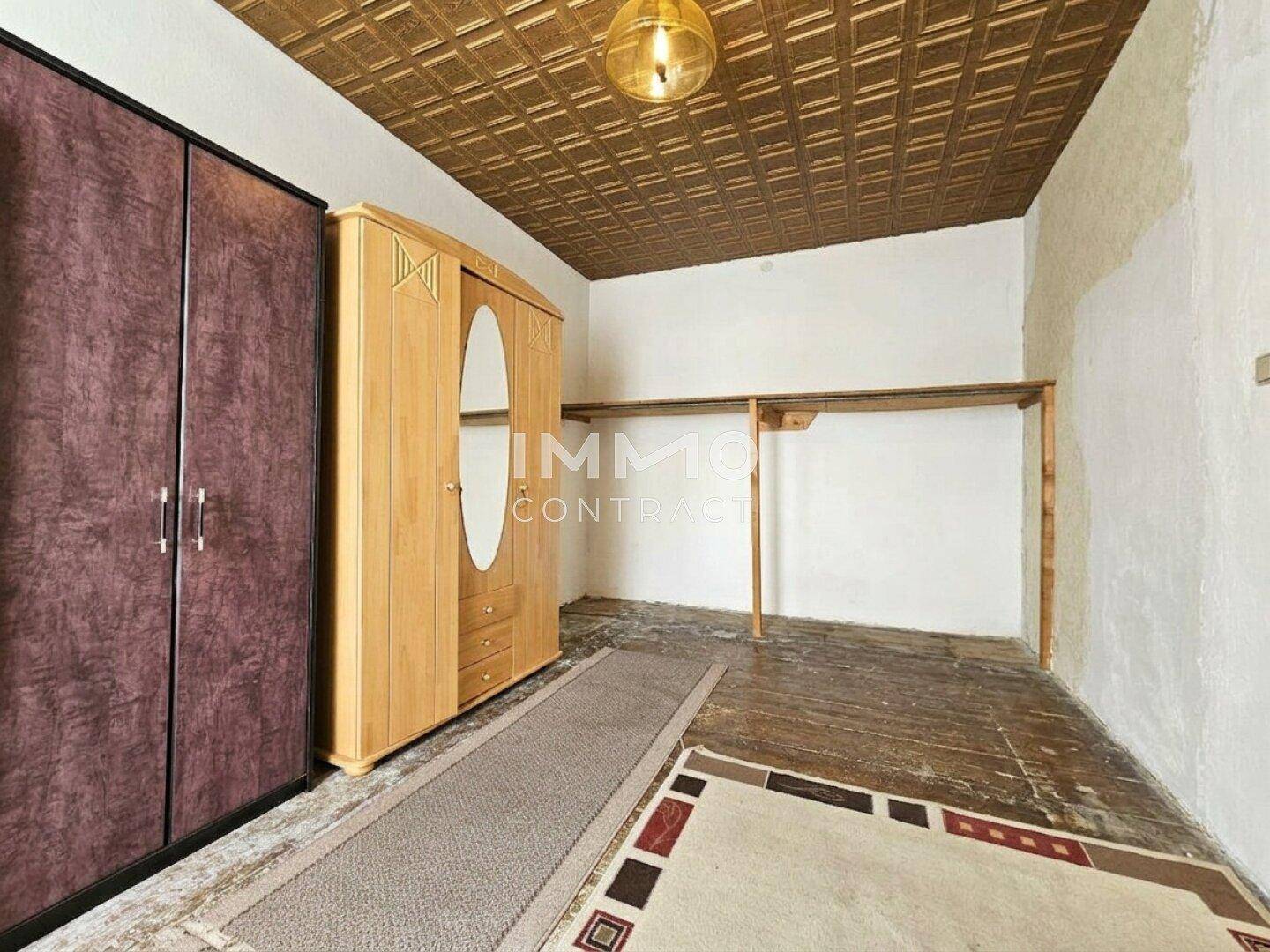 Schlafzimmer mit Kleiderschränken und Holzdecke, bietet Stauraum und eine einfache Einrichtung.