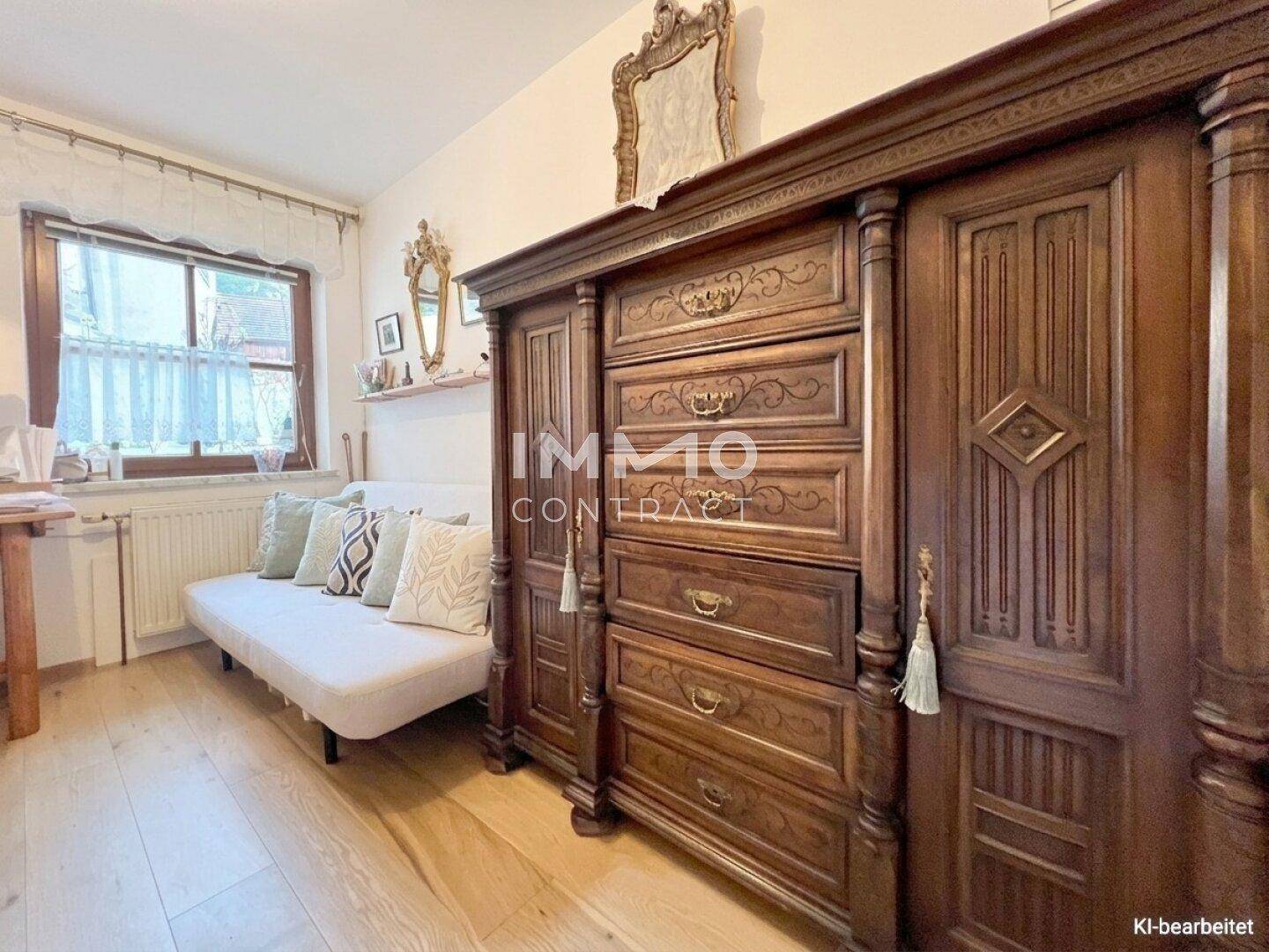 Gemütliches Zimmer mit antikem Holzschrank, Tagesbett und Blick ins Grüne.