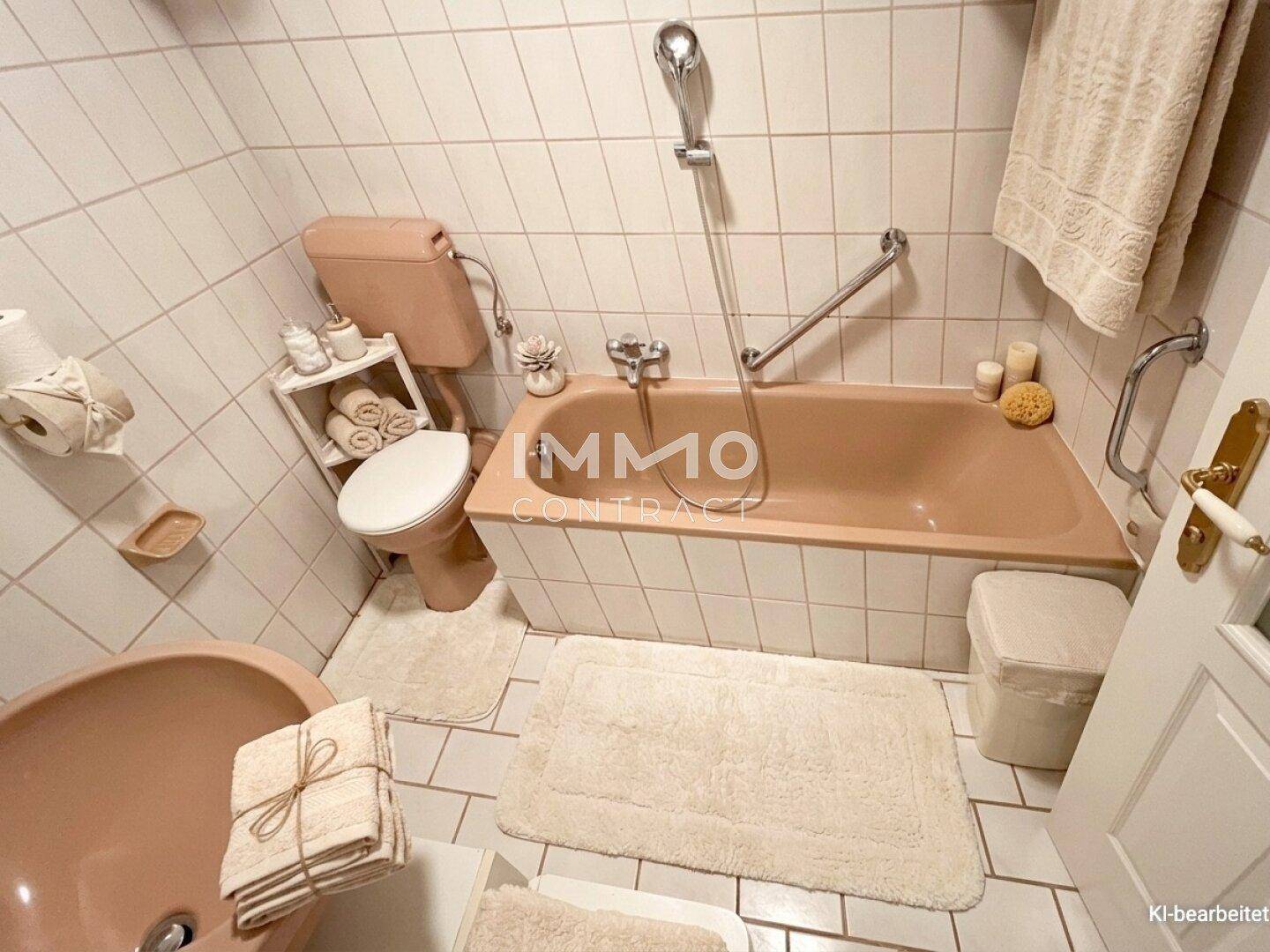 Badezimmer mit weißen Fliesen, Badewanne in Pastellfarbe und Haltegriffen.