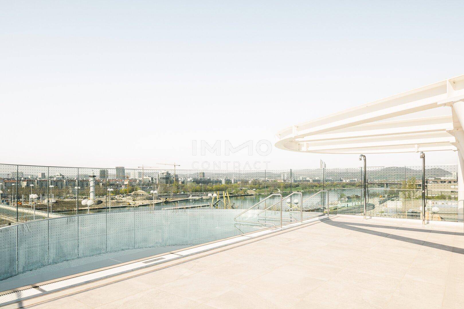 Dachterrasse mit Infinity-Pool und weitem Blick über die Stadt und den Fluss.