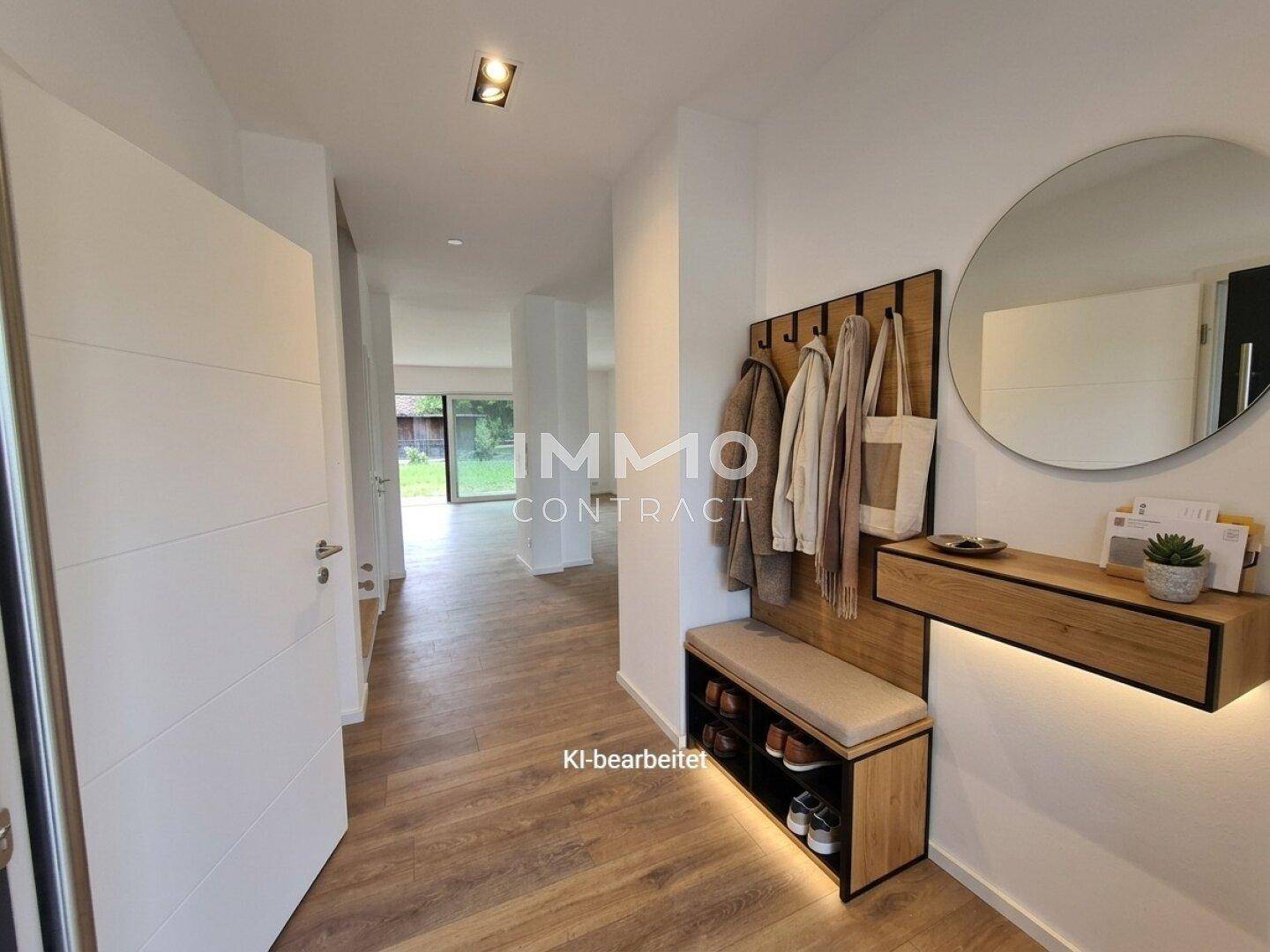 Moderner Eingangsbereich mit Garderobe, Spiegel und Holzoptikboden, der zu den Wohnräumen führt.