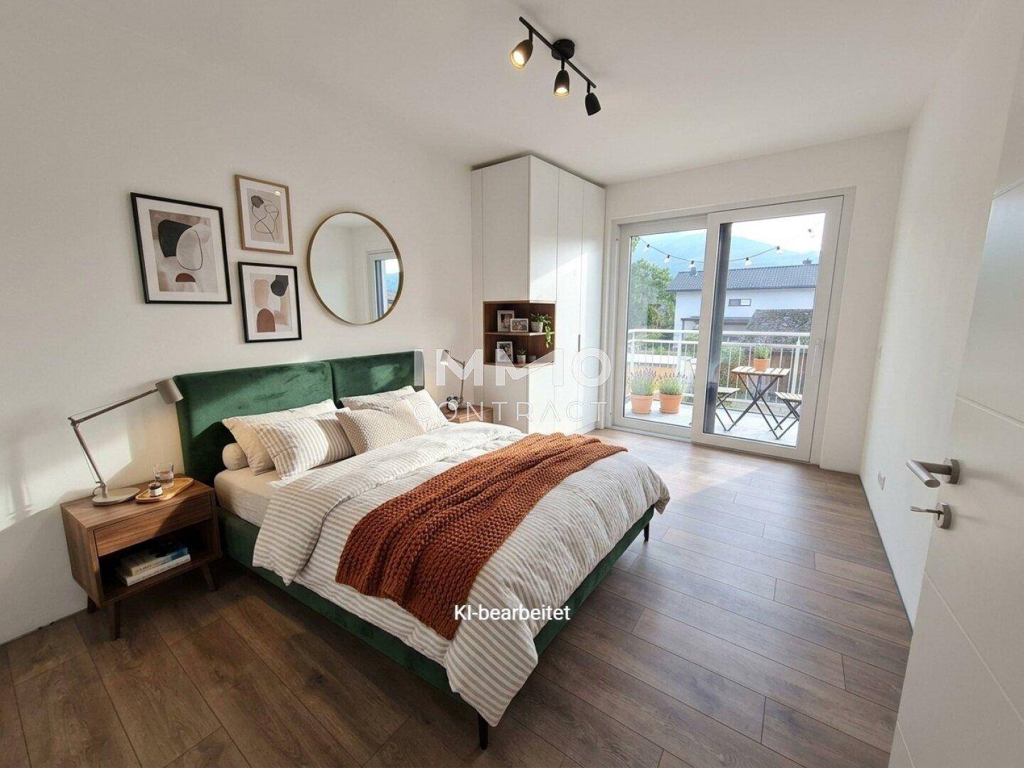 Gemütliches Schlafzimmer mit grünem Samtbett, Kleiderschrank und Zugang zu einem kleinen Balkon.