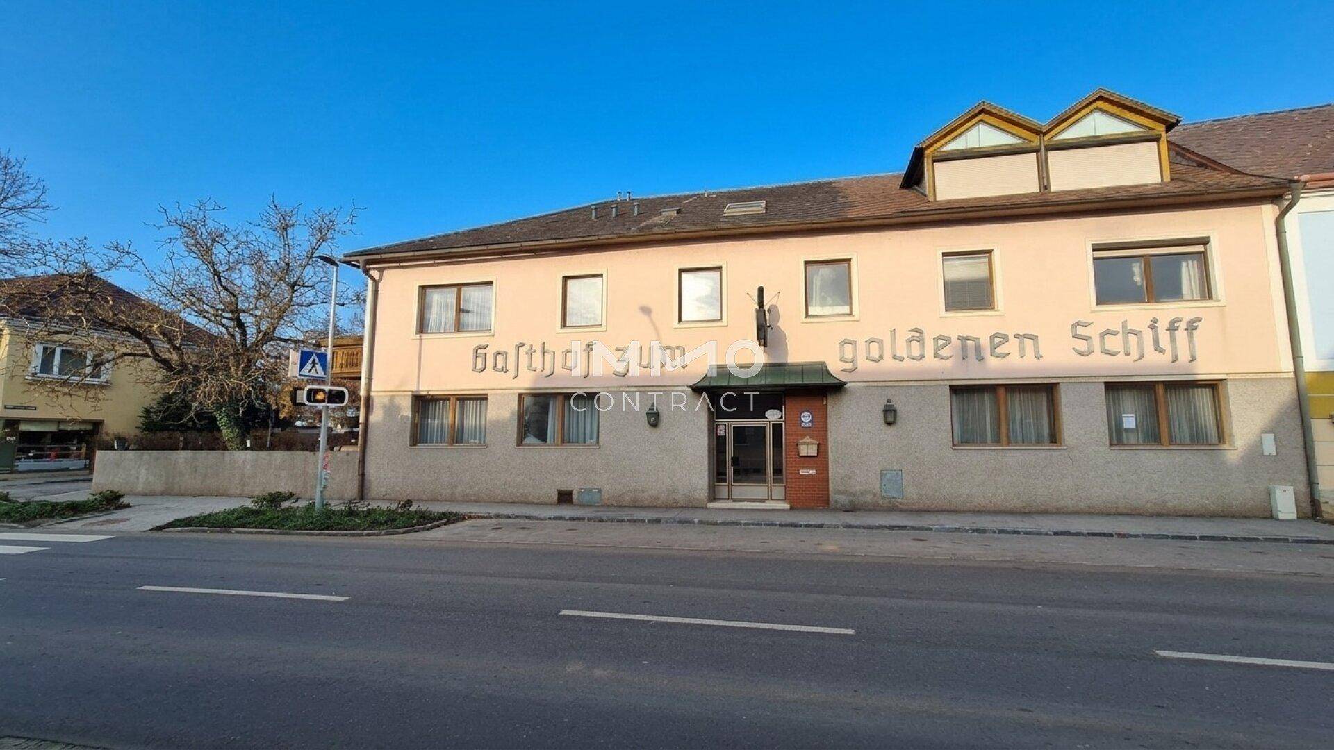 Fassade eines Gasthofs mit traditioneller Beschriftung an einer Straße gelegen.