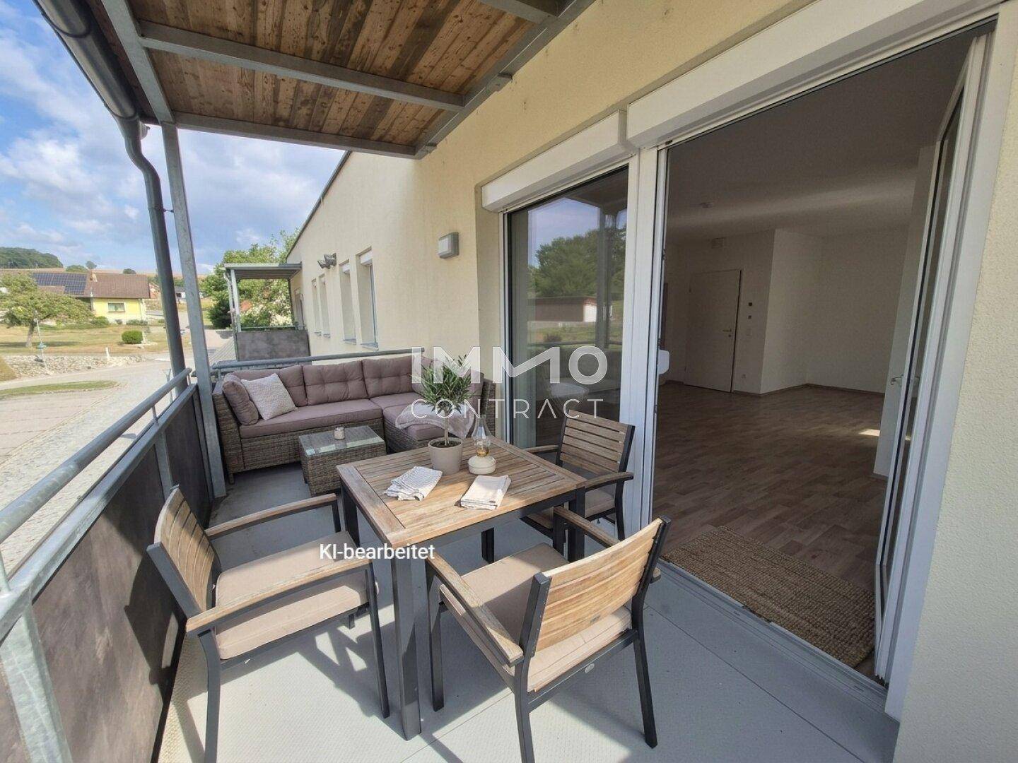 Gemütlicher Balkon mit Sitzgelegenheiten und einem Tisch, der einen Blick ins Grüne bietet.