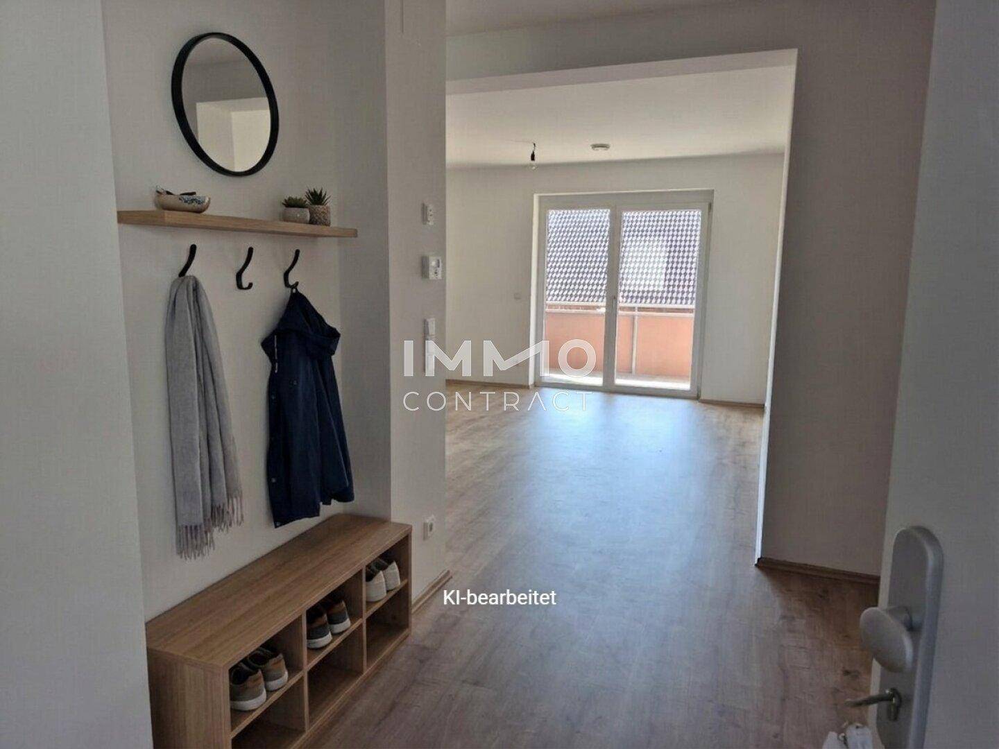 Heller Eingangsbereich mit Garderobe und Schuhbank, führt zu einem Wohnbereich mit Balkonzugang.