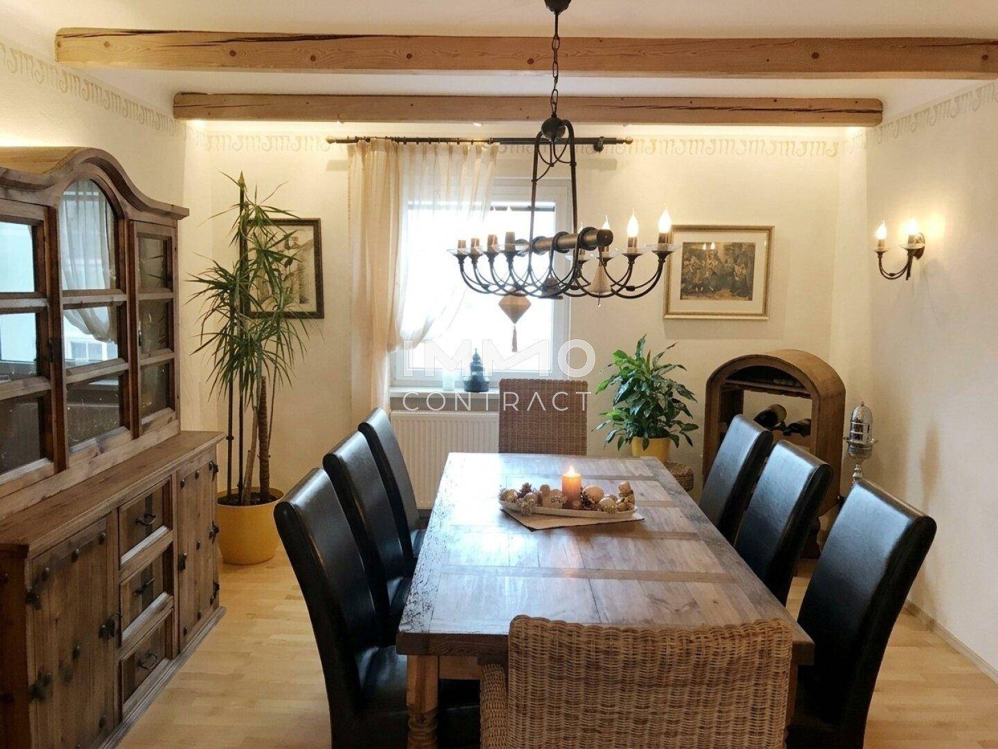 Gemütlicher Essbereich mit Holztisch, passenden Möbeln und sichtbaren Deckenbalken.