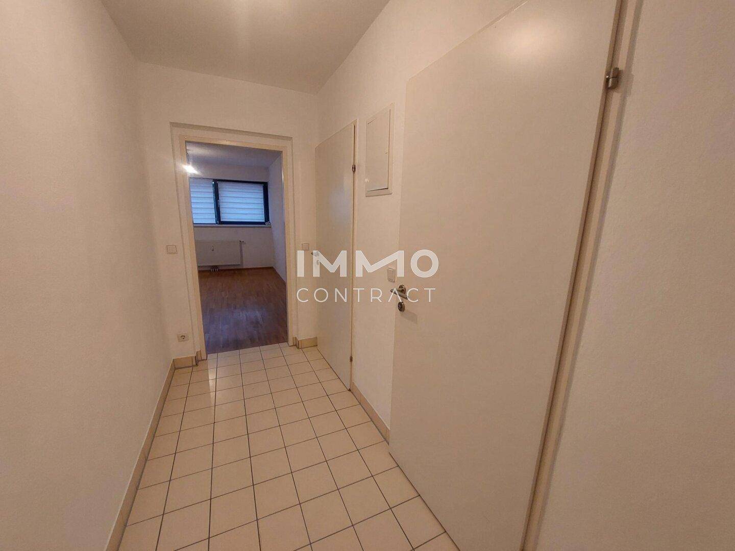 Flur mit Fliesenboden und Türen, der zu den verschiedenen Zimmern der Wohnung führt.