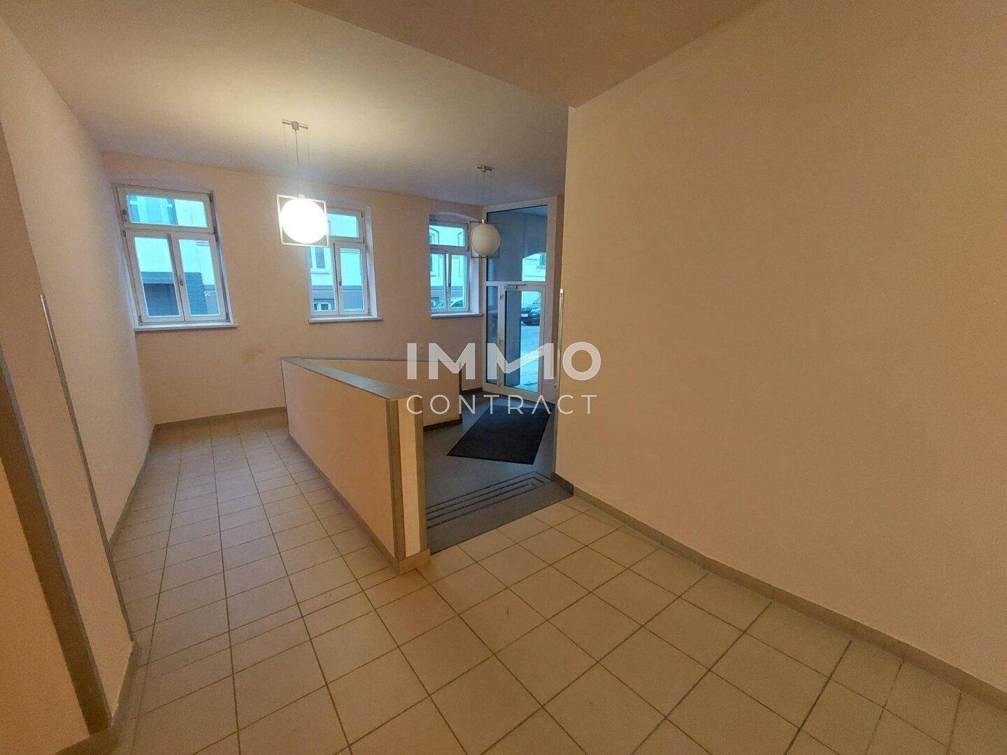 Heller Eingangsbereich mit Fliesenboden und Zugang zum Treppenhaus oder weiteren Räumen.