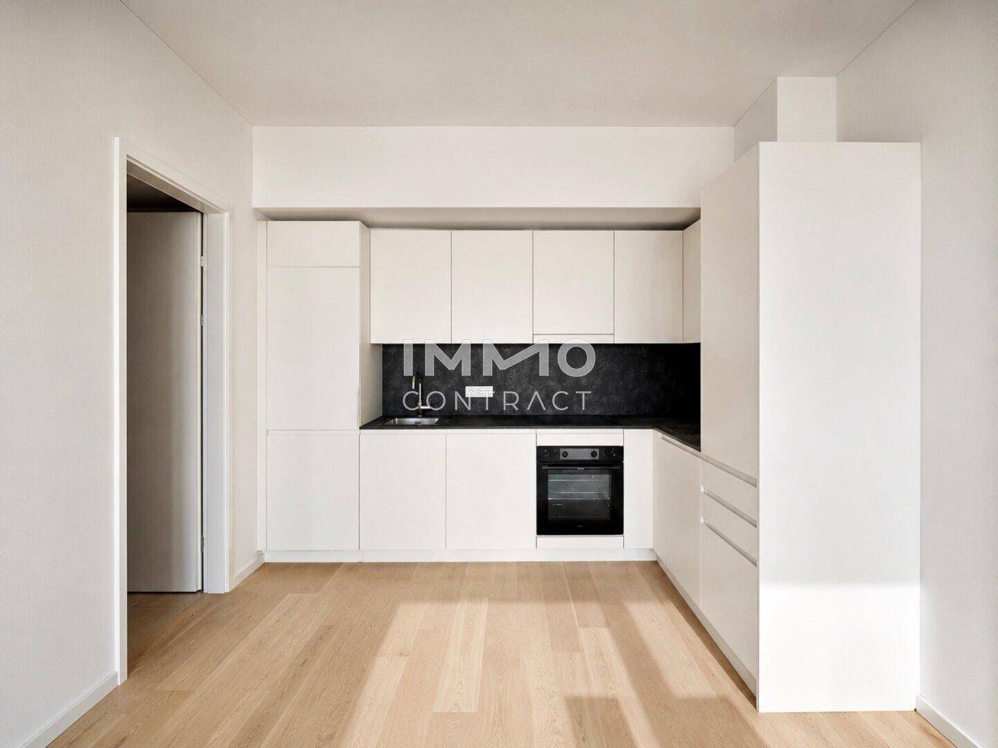 Moderne Einbauküche mit weißen Fronten, schwarzer Arbeitsplatte und integriertem Backofen.