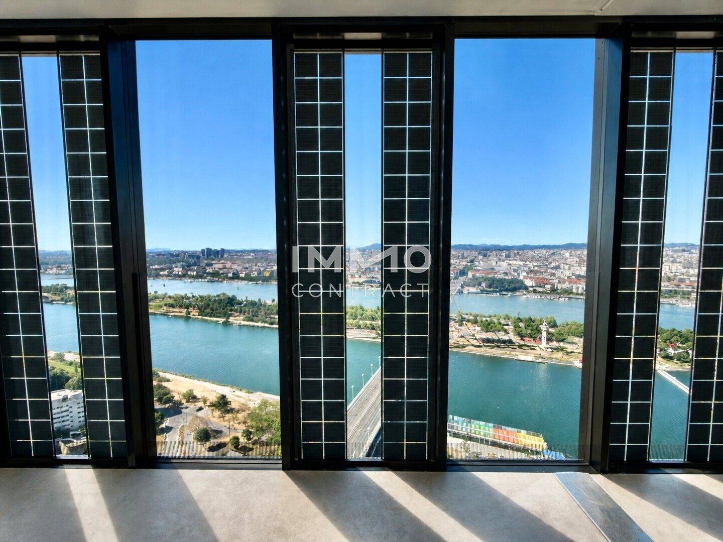 Atemberaubender Ausblick auf die Stadt und den Fluss durch die raumhohen Fenster eines modernen Apartments.