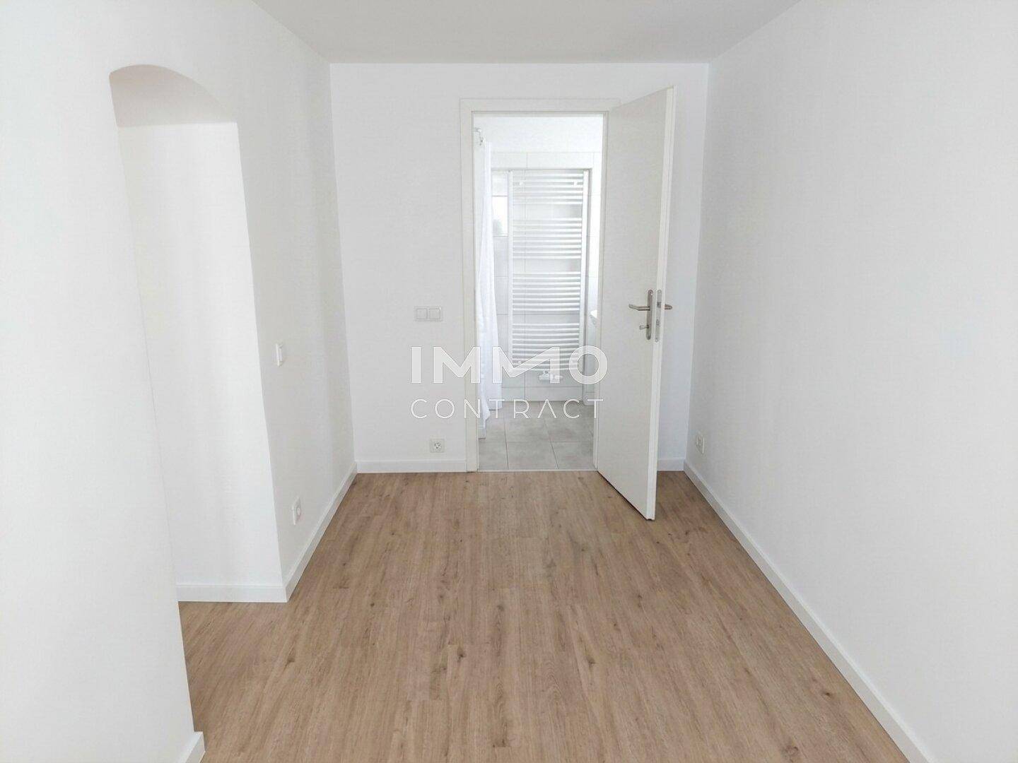 Heller Flur mit Laminatboden und Zugang zu einem weiteren Raum.