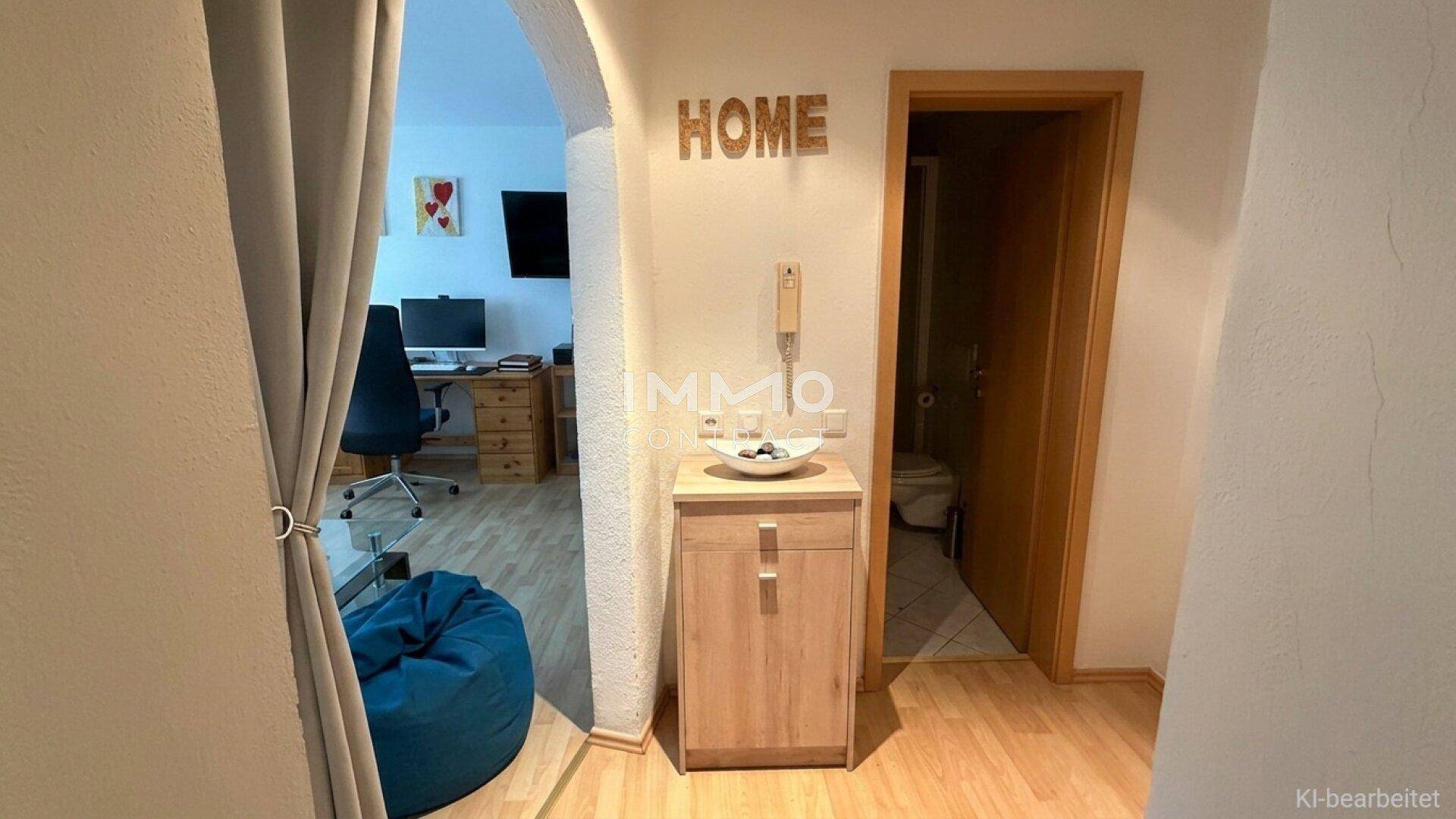 Eingangsbereich mit Holzboden, Blick in den Wohnbereich und Zugang zu einem separaten WC.